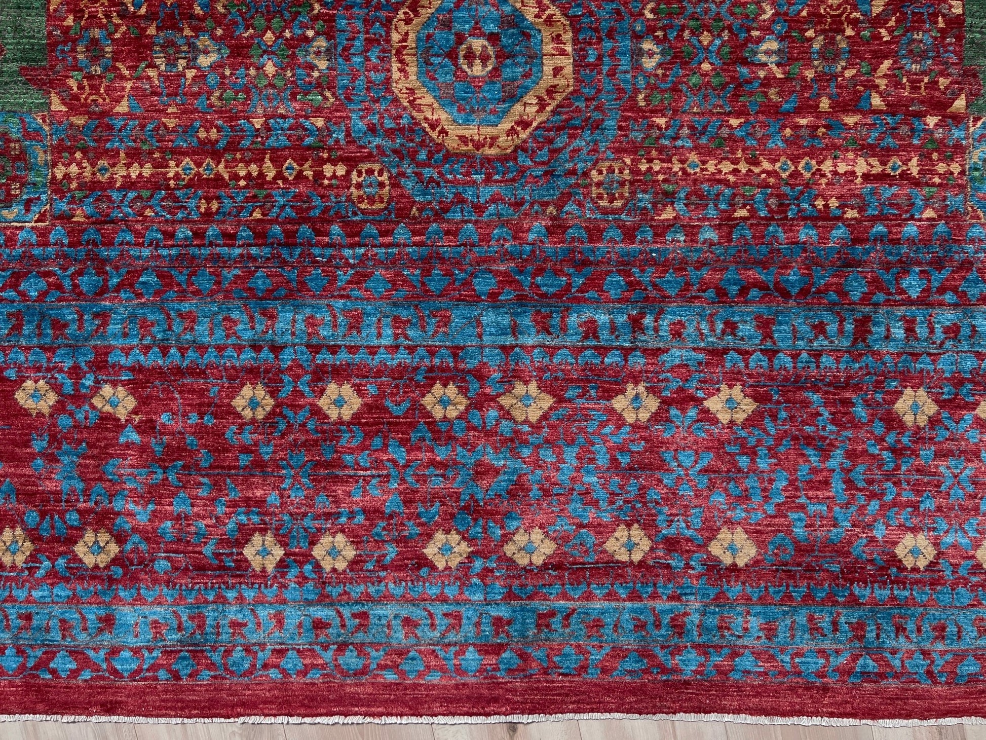 Regal Mamluk area rug made from luxurious Ghazni wool, featuring a rich color combination of deep reds, blues, golds, and greens. This handmade carpet showcases intricate geometric patterns and medallions, adding elegance and sophistication to any living room, bedroom, dining area, or office. Available from the best rug shop in the San Francisco Bay Area, this luxury rug comes with free shipping across the U.S.