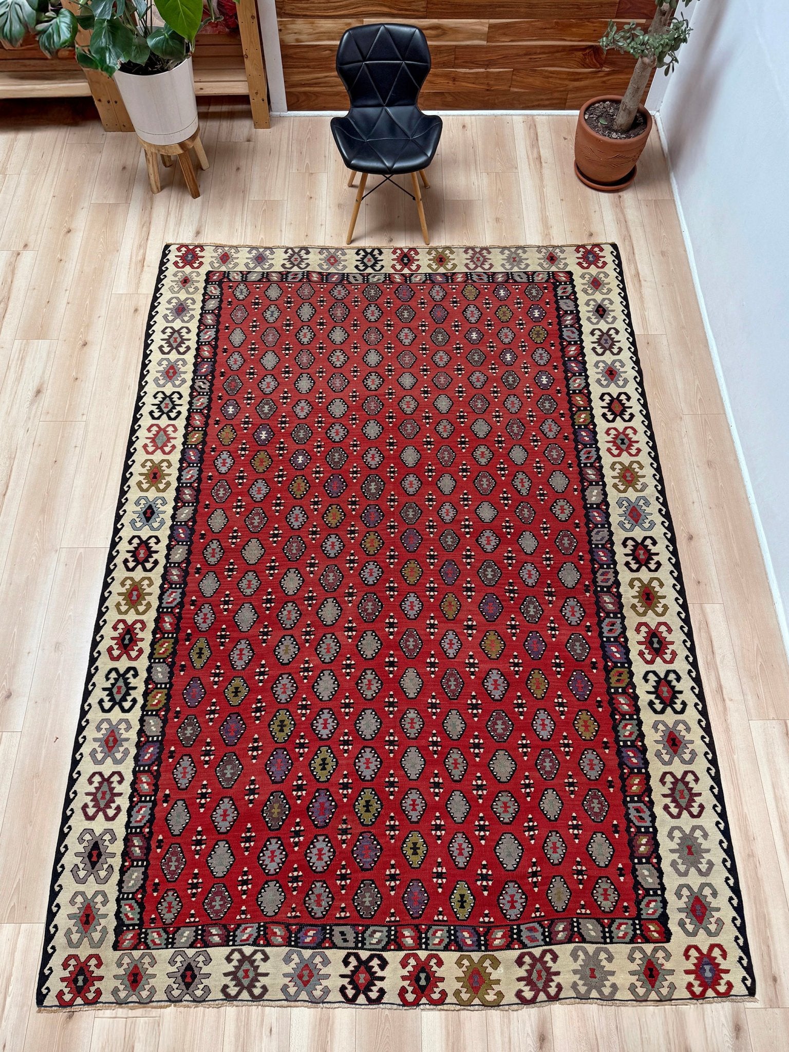 Decorative rug with intricate pattern on a red background. Vintage Pirot kilim with warm madder red field and repeating geometric medallions, handwoven wool flatweave rug with ivory border, approx. 7x10.
