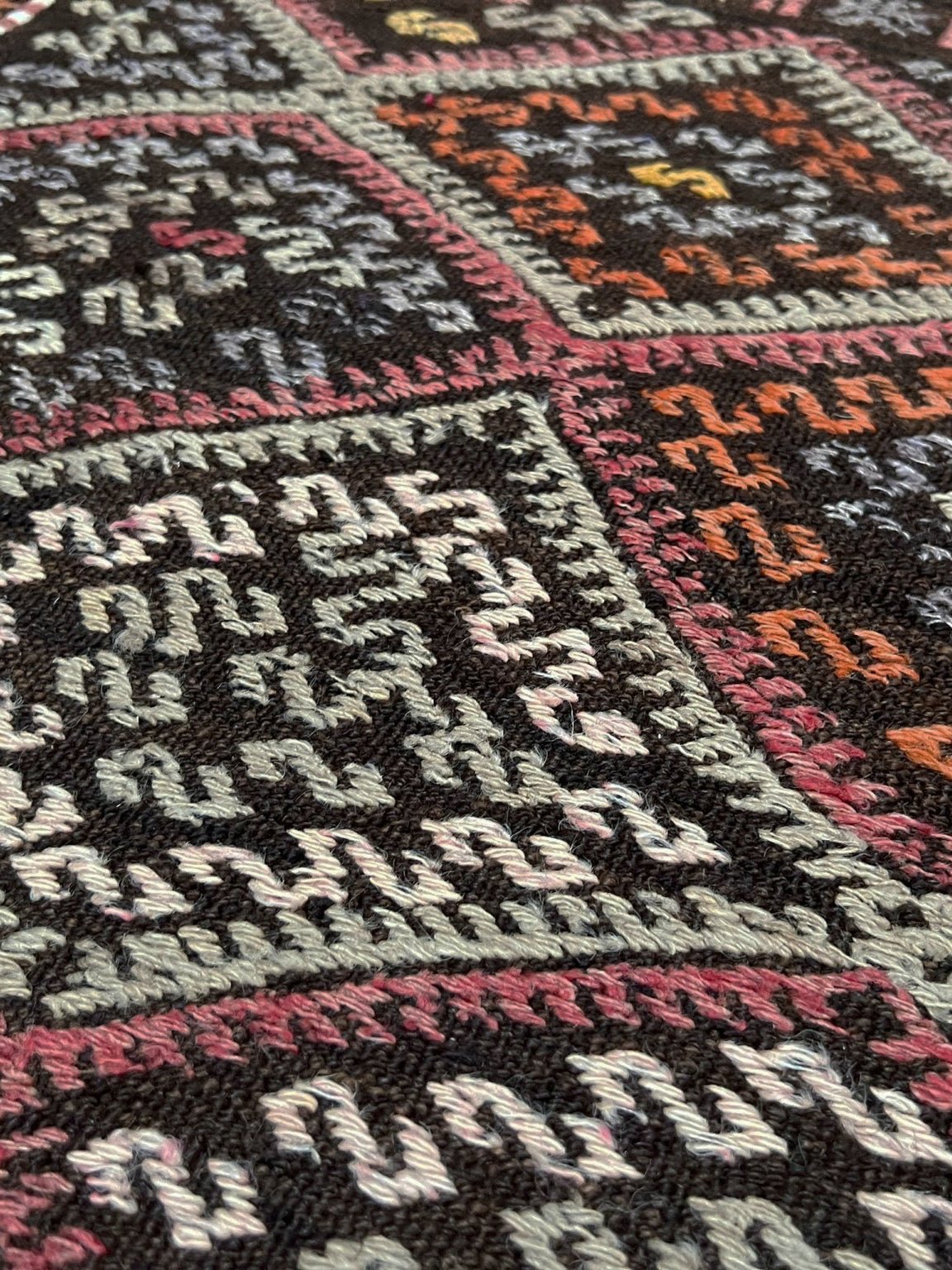 Vintage Malatya Cicim Turkish kilim rug with embroidered diamond motifs in rose, amber, and ivory on a charcoal brown field — handmade wool flatweave from the 1940s, available at Indigo Rugs, the best rug shop in San Francisco Bay Area, Burlingame CA.