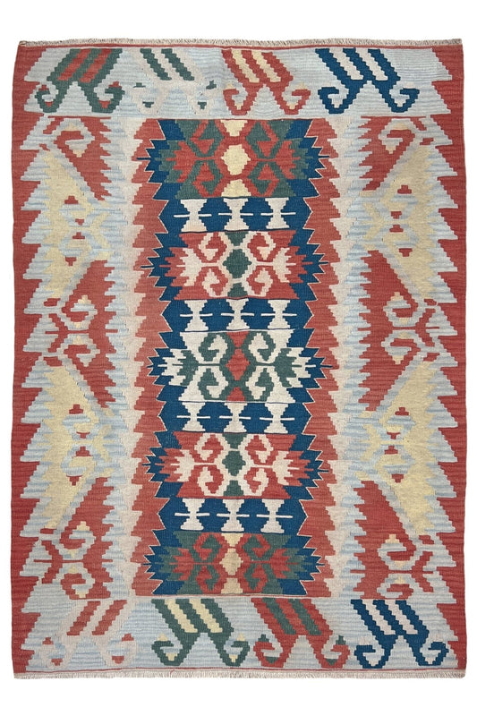 Woven rug with geometric pattern featuring red, blue, and beige colors. Woven turkish kilim rug with geometric pattern featuring red, blue, and beige colors. 