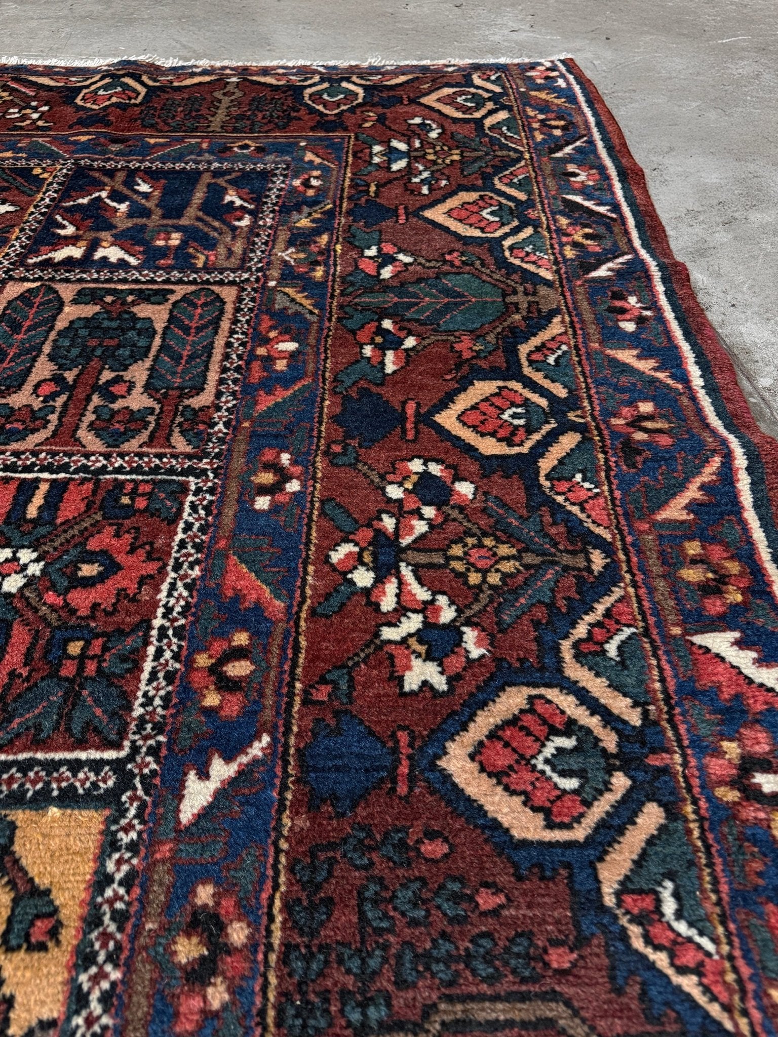 10x13 handmade Persian Bakhtiari vintage rug with garden panel design, floral motifs, and red and navy tones — shown in living room at Indigo Rugs, Burlingame — San Francisco Bay Area with free shipping