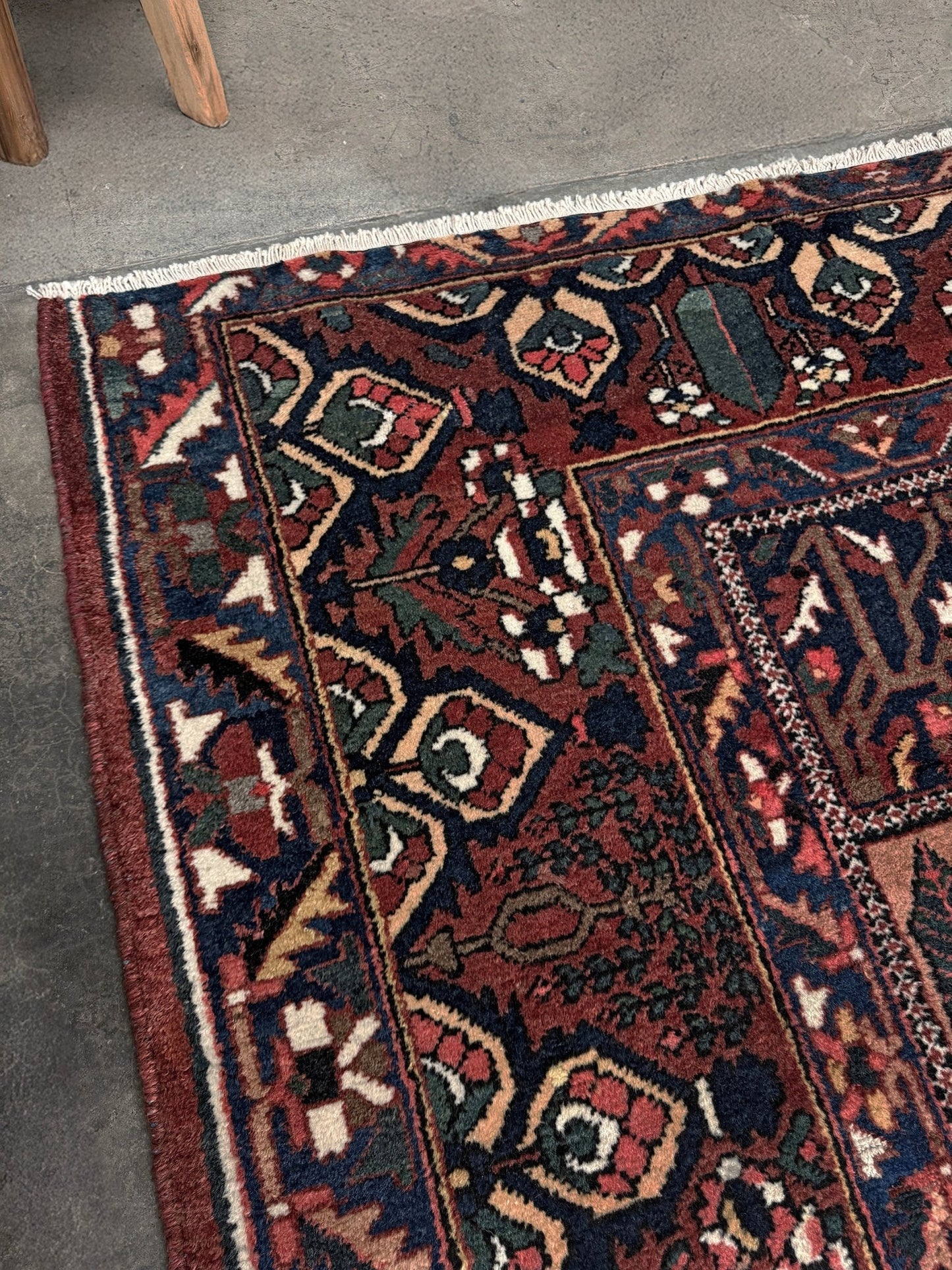10x13 handmade Persian Bakhtiari vintage rug with garden panel design, floral motifs, and red and navy tones — shown in living room at Indigo Rugs, Burlingame — San Francisco Bay Area with free shipping