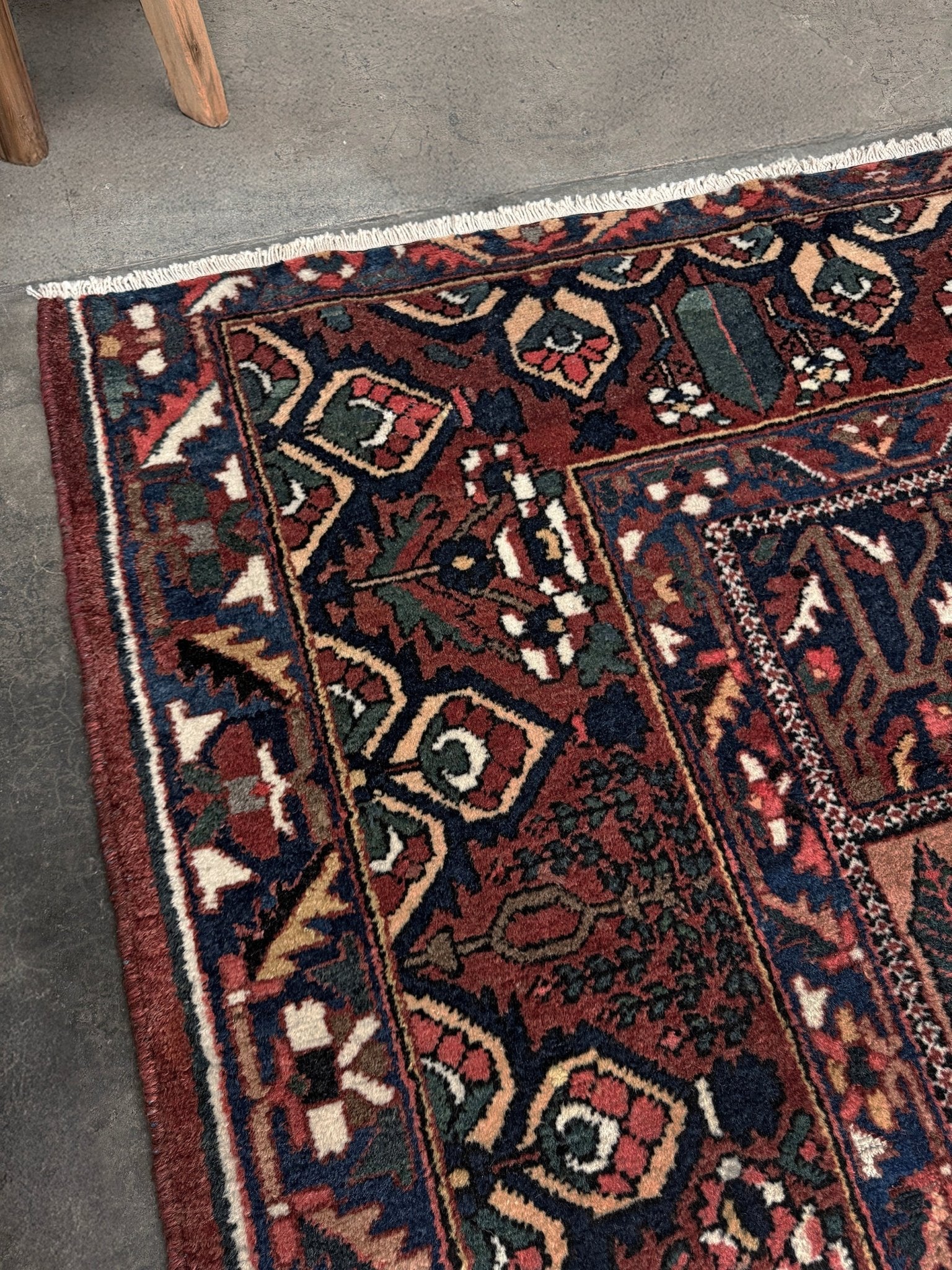 10x13 handmade Persian Bakhtiari vintage rug with garden panel design, floral motifs, and red and navy tones — shown in living room at Indigo Rugs, Burlingame — San Francisco Bay Area with free shipping