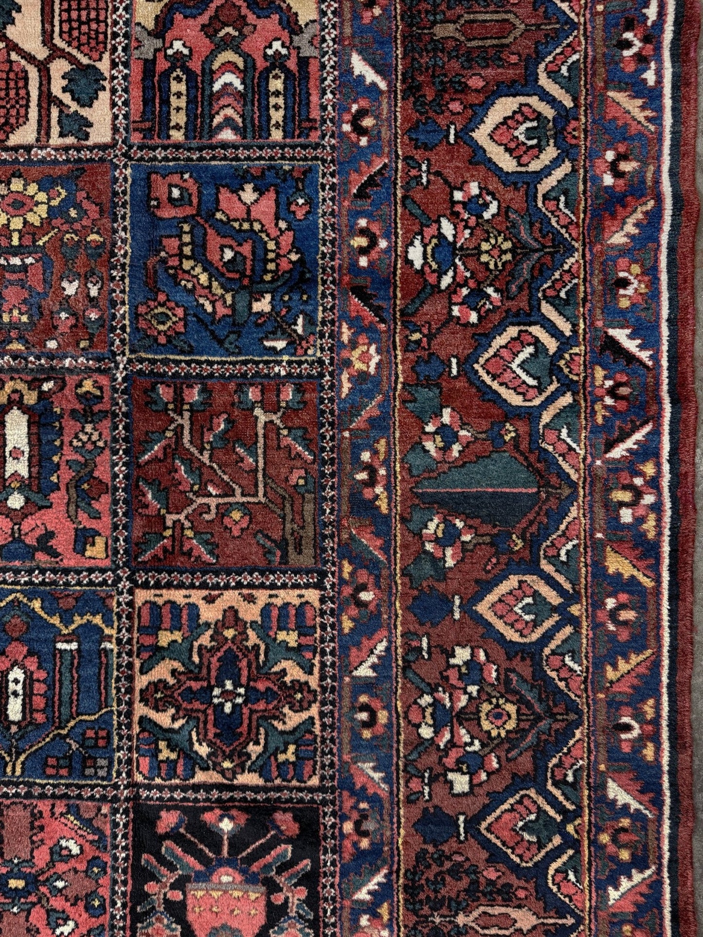10x13 handmade Persian Bakhtiari vintage rug with garden panel design, floral motifs, and red and navy tones — shown in living room at Indigo Rugs, Burlingame — San Francisco Bay Area with free shipping