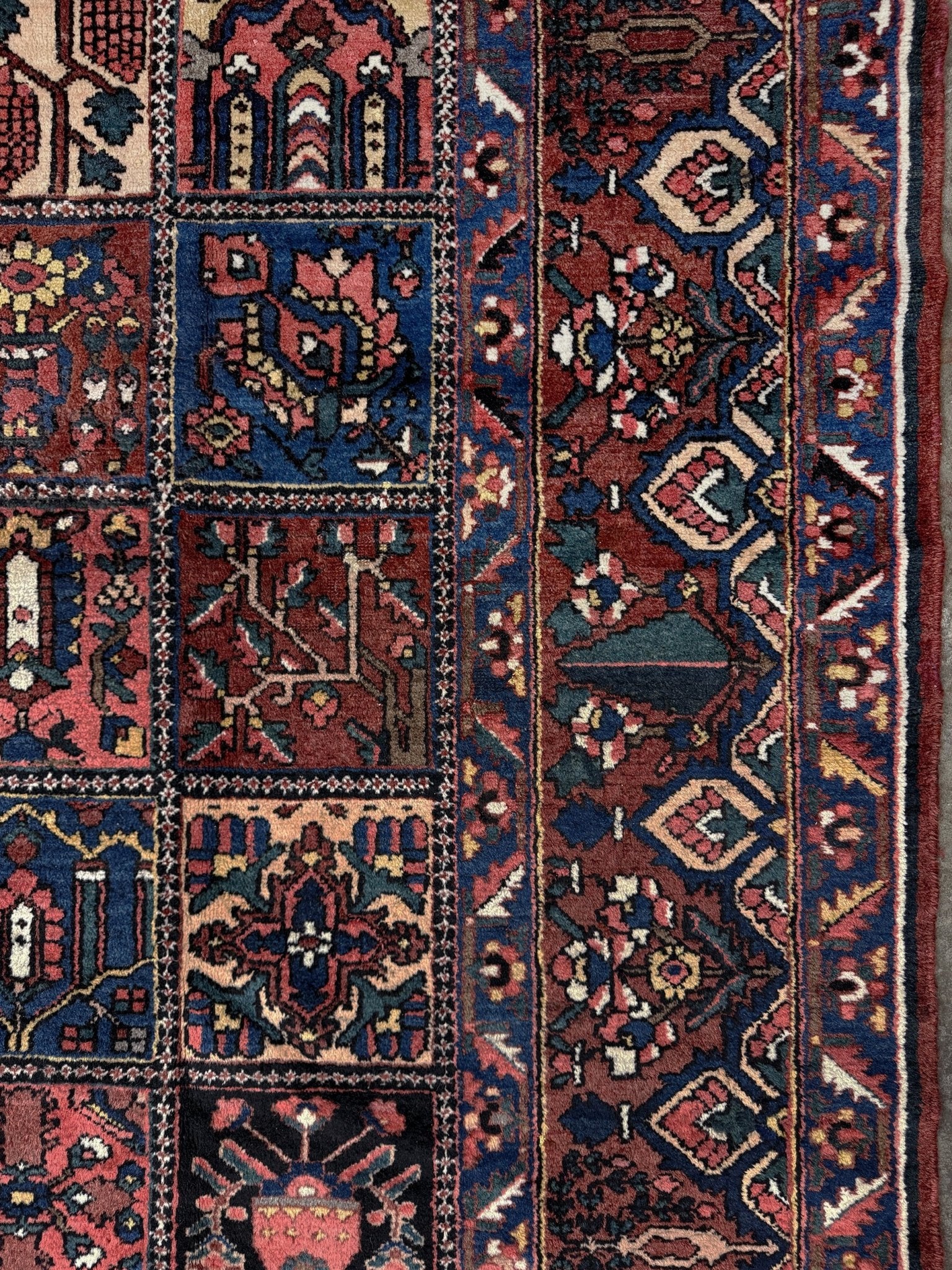 10x13 handmade Persian Bakhtiari vintage rug with garden panel design, floral motifs, and red and navy tones — shown in living room at Indigo Rugs, Burlingame — San Francisco Bay Area with free shipping