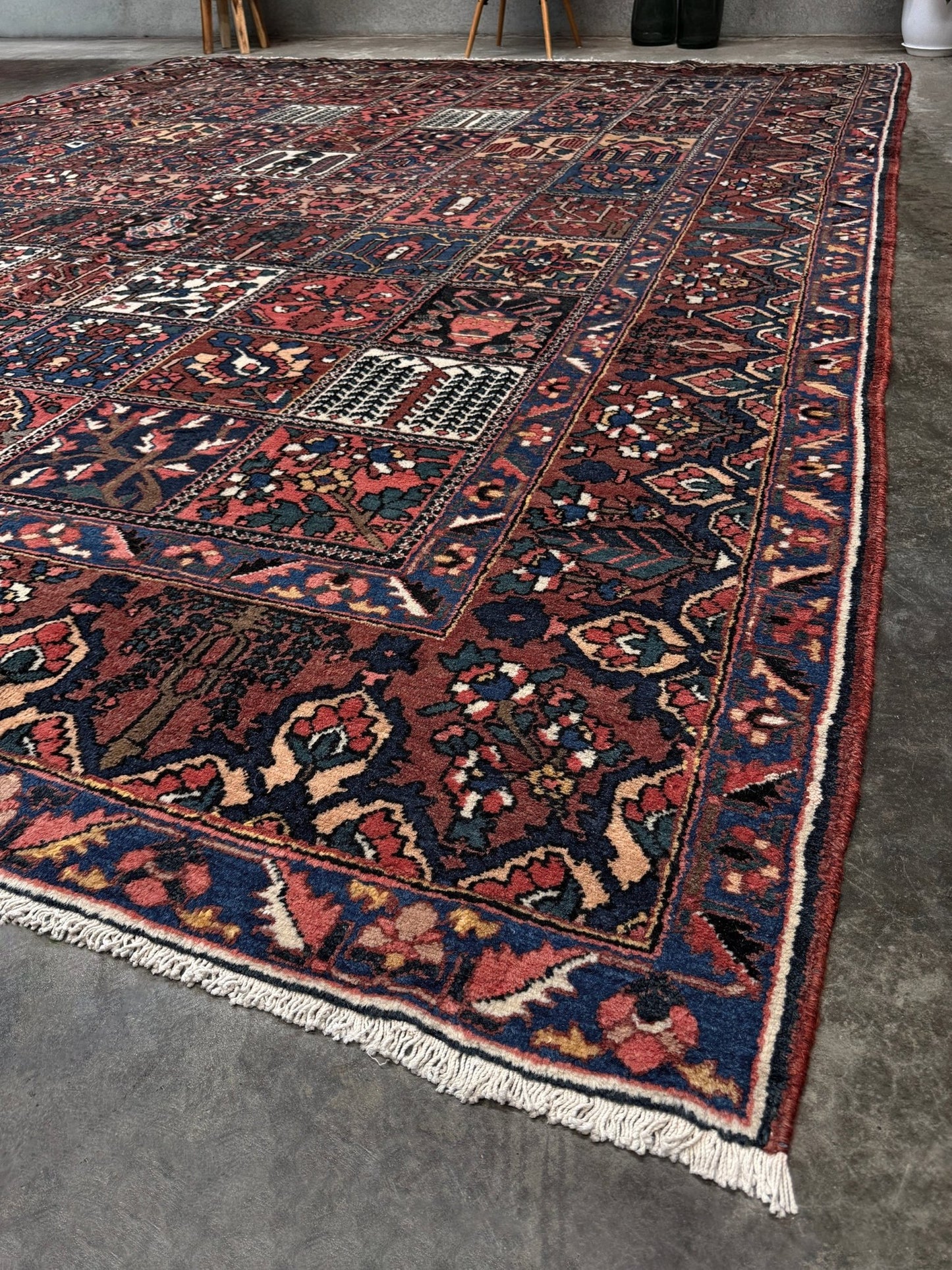 10x13 handmade Persian Bakhtiari vintage rug with garden panel design, floral motifs, and red and navy tones — shown in living room at Indigo Rugs, Burlingame — San Francisco Bay Area with free shipping