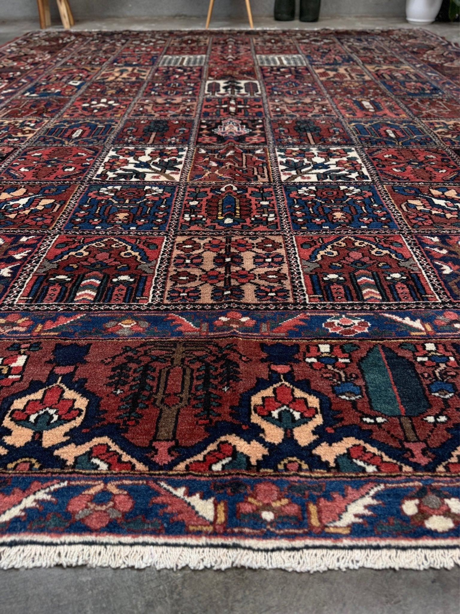 10x13 handmade Persian Bakhtiari vintage rug with garden panel design, floral motifs, and red and navy tones — shown in living room at Indigo Rugs, Burlingame — San Francisco Bay Area with free shipping