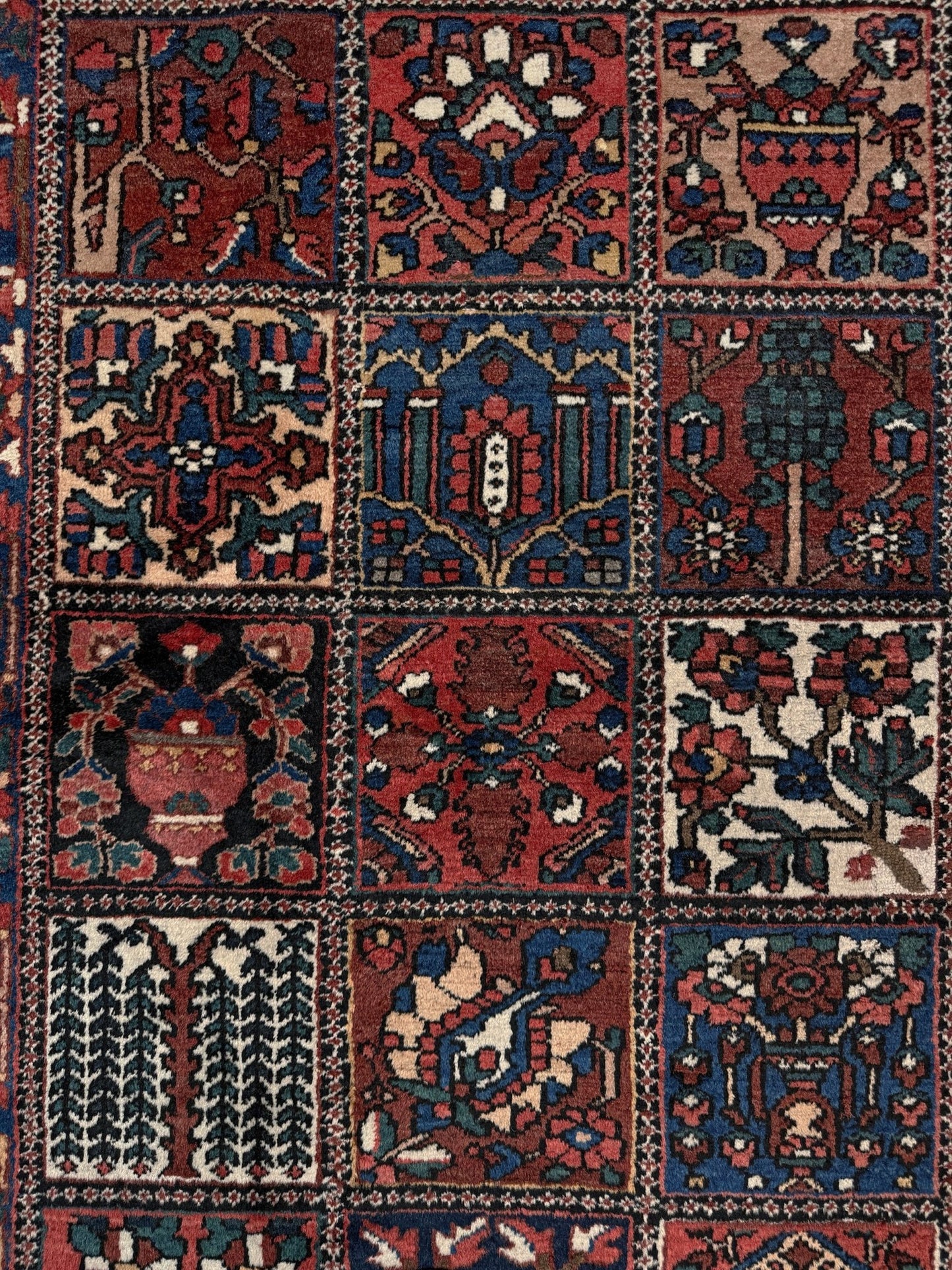 10x13 handmade Persian Bakhtiari vintage rug with garden panel design, floral motifs, and red and navy tones — shown in living room at Indigo Rugs, Burlingame — San Francisco Bay Area with free shipping