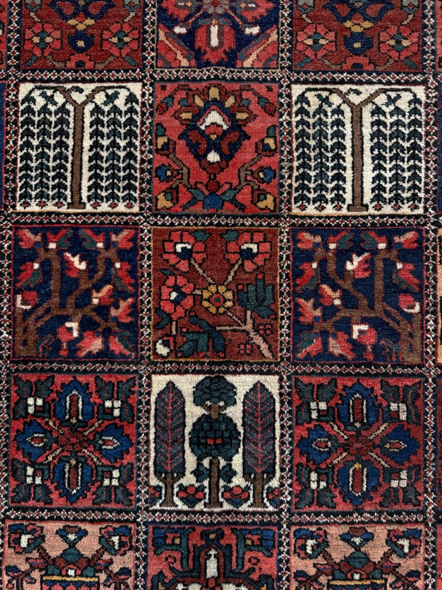 10x13 handmade Persian Bakhtiari vintage rug with garden panel design, floral motifs, and red and navy tones — shown in living room at Indigo Rugs, Burlingame — San Francisco Bay Area with free shipping