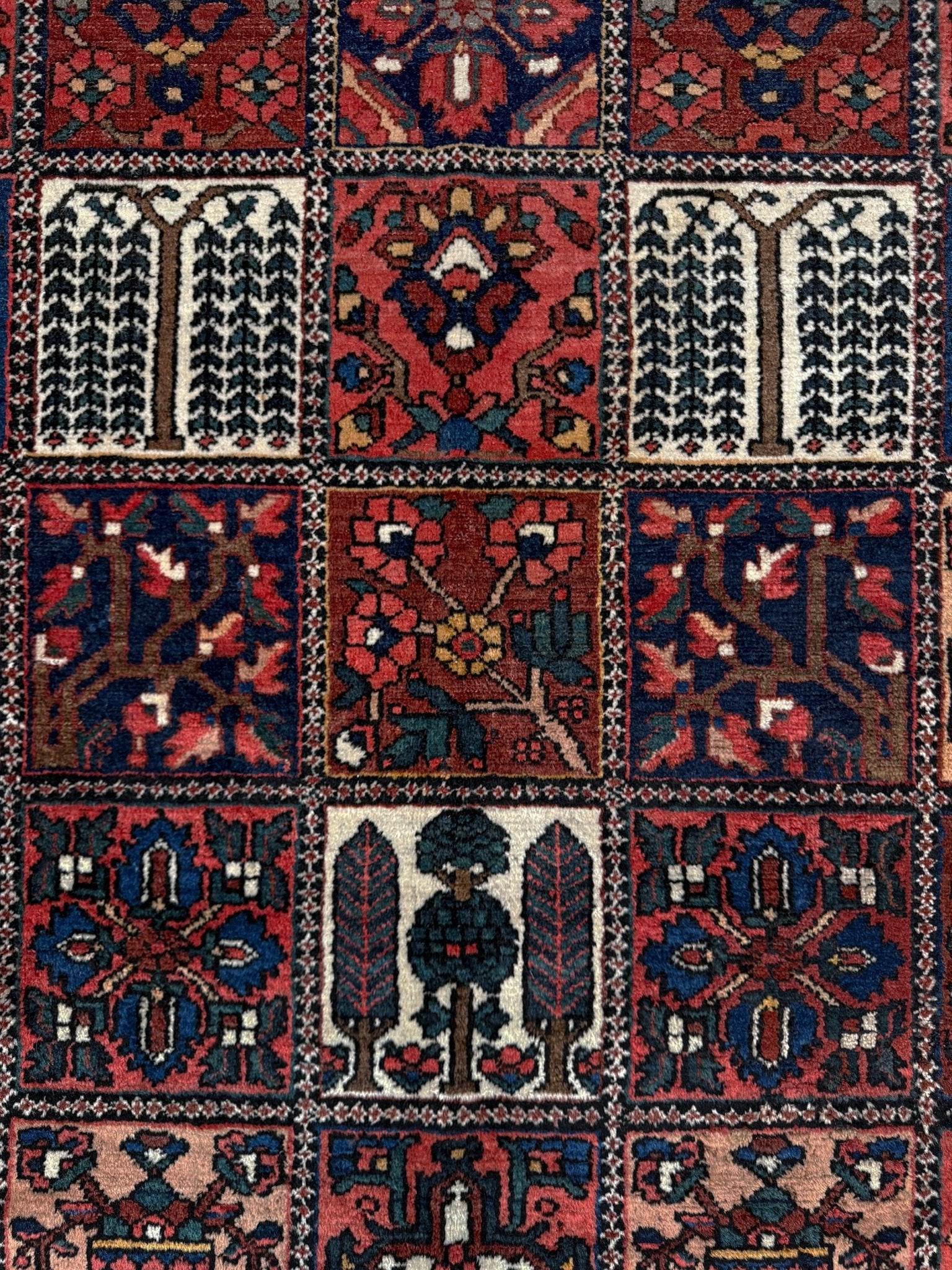 10x13 handmade Persian Bakhtiari vintage rug with garden panel design, floral motifs, and red and navy tones — shown in living room at Indigo Rugs, Burlingame — San Francisco Bay Area with free shipping