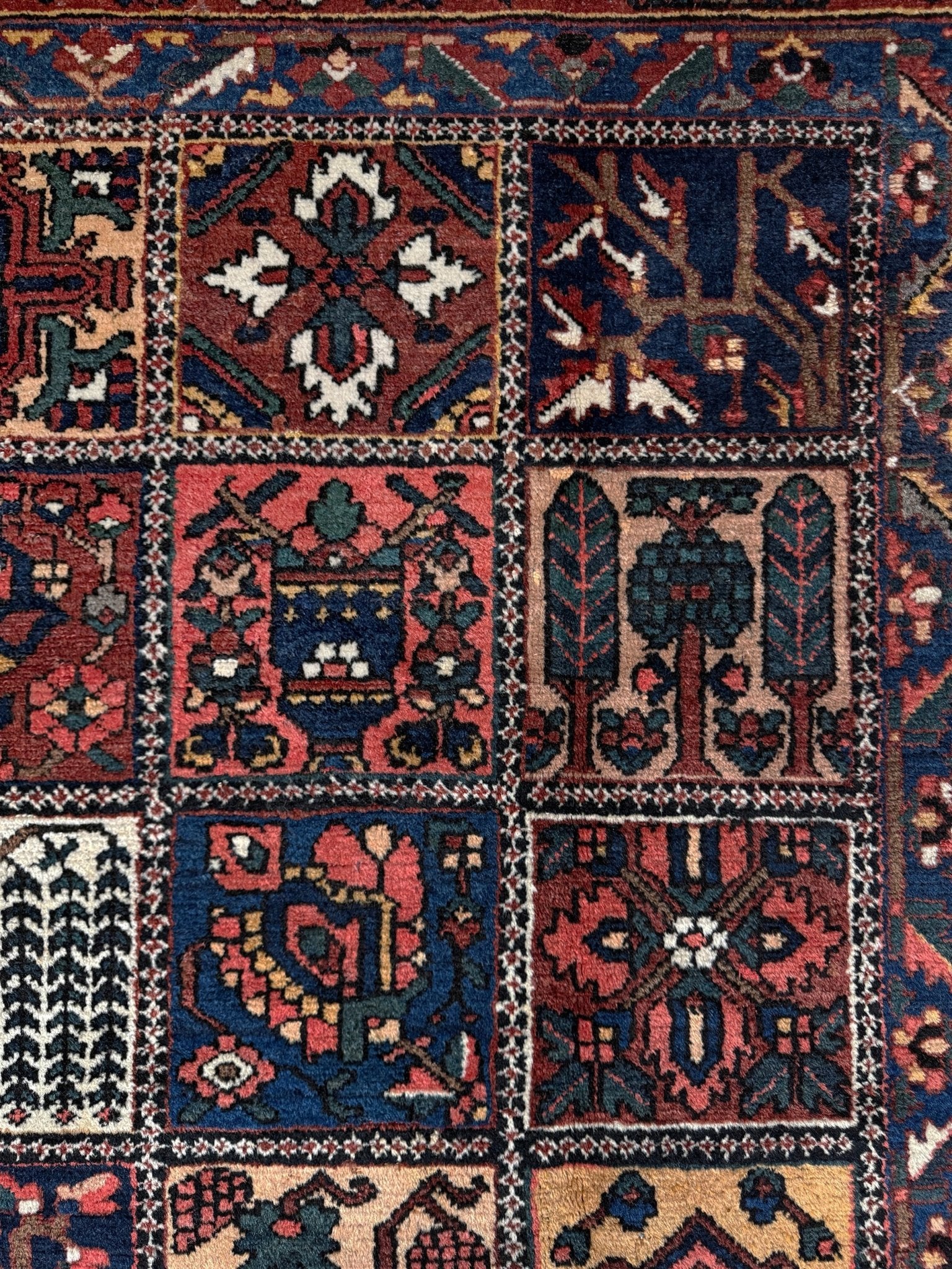 10x13 handmade Persian Bakhtiari vintage rug with garden panel design, floral motifs, and red and navy tones — shown in living room at Indigo Rugs, Burlingame — San Francisco Bay Area with free shipping