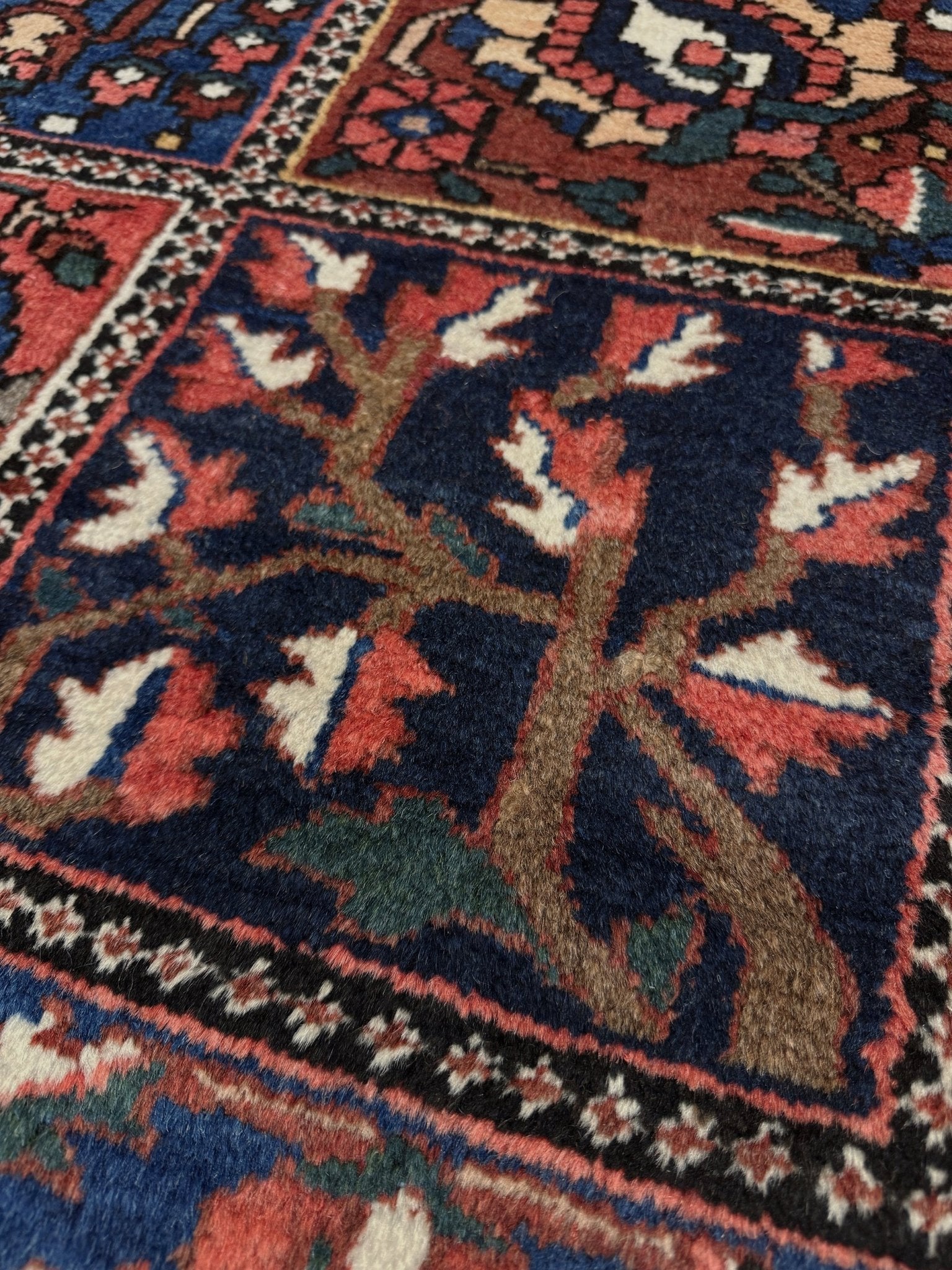10x13 handmade Persian Bakhtiari vintage rug with garden panel design, floral motifs, and red and navy tones — shown in living room at Indigo Rugs, Burlingame — San Francisco Bay Area with free shipping