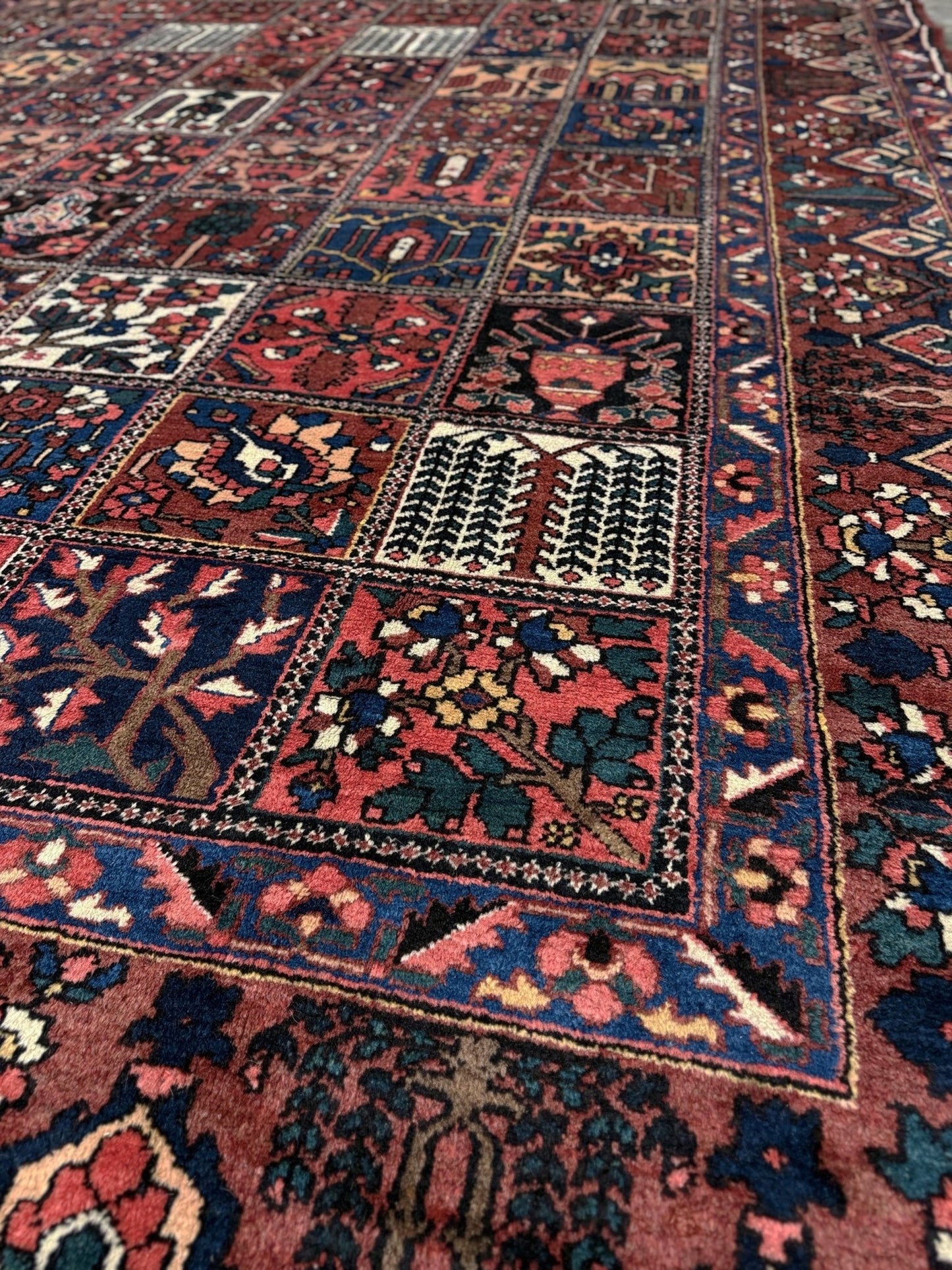 10x13 handmade Persian Bakhtiari vintage rug with garden panel design, floral motifs, and red and navy tones — shown in living room at Indigo Rugs, Burlingame — San Francisco Bay Area with free shipping