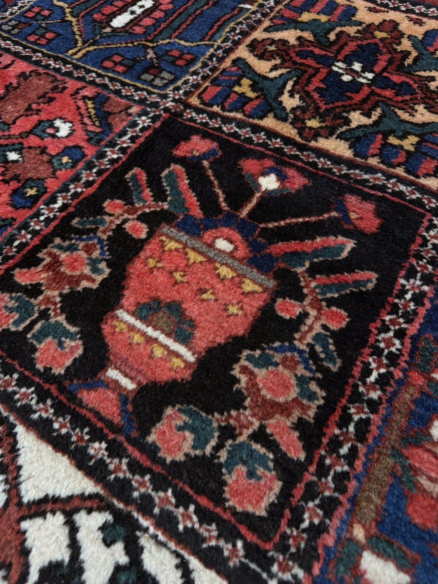10x13 handmade Persian Bakhtiari vintage rug with garden panel design, floral motifs, and red and navy tones — shown in living room at Indigo Rugs, Burlingame — San Francisco Bay Area with free shipping