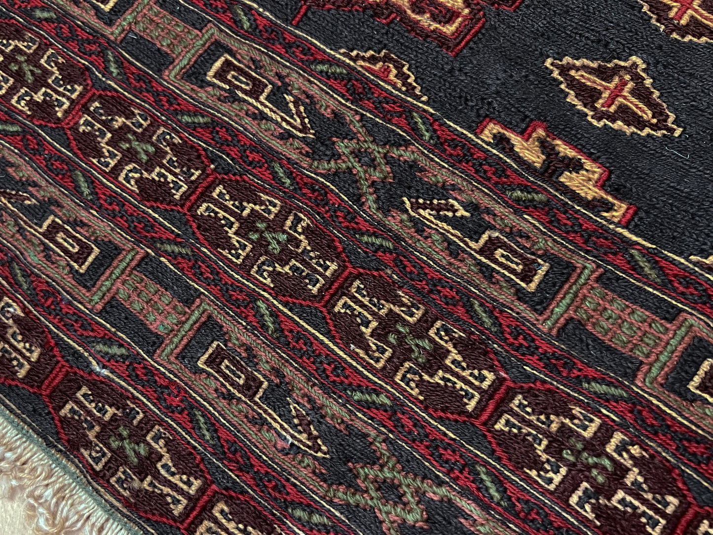Vintage Caucasian Soumak flatweave rug with charcoal gray field, madder red rose motifs, and intricate tribal borders — handmade wool wall hanging from the 1950s, available at Indigo Rugs, the best rug shop in San Francisco Bay Area, Burlingame CA.