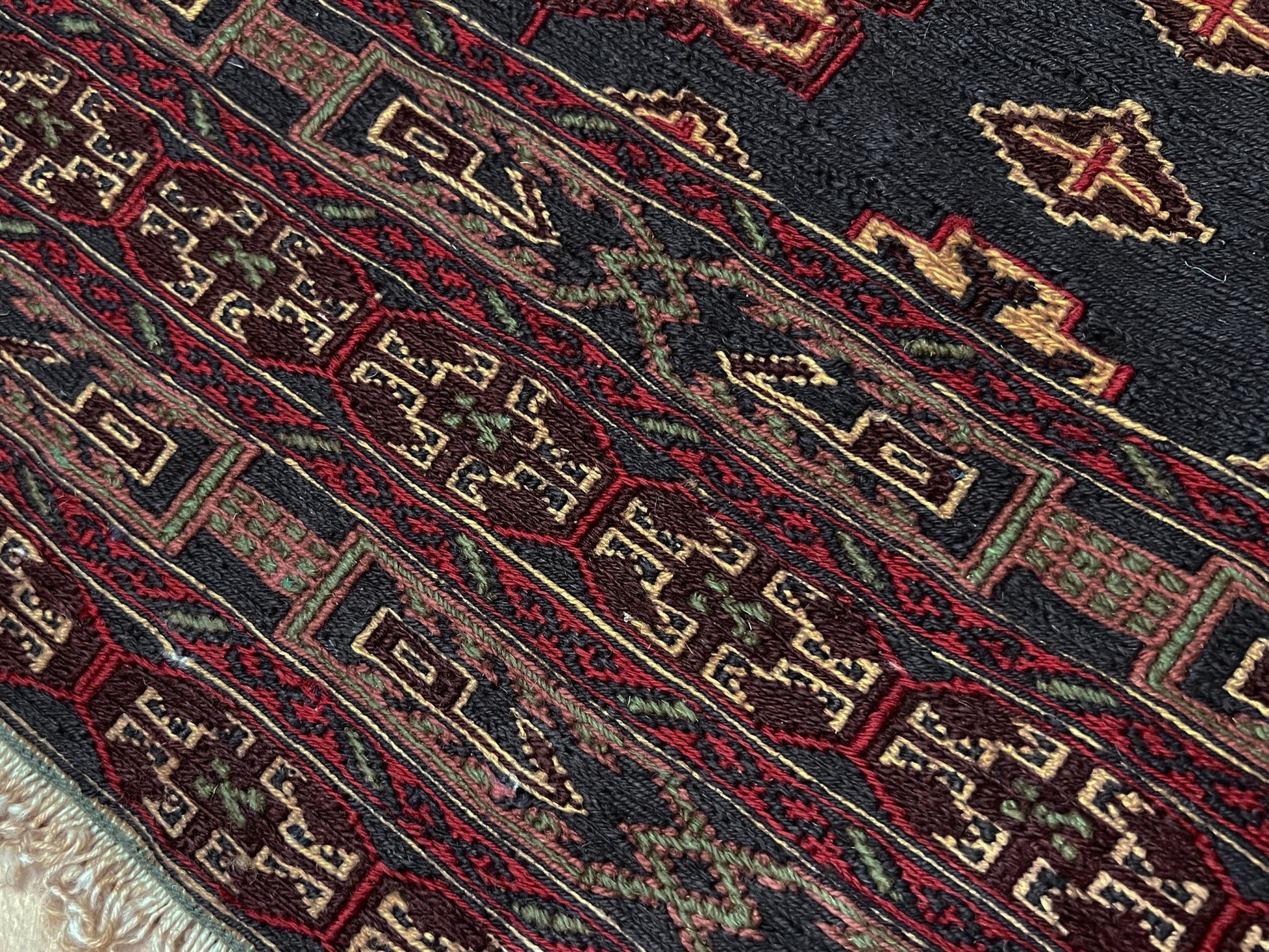 Vintage Caucasian Soumak flatweave rug with charcoal gray field, madder red rose motifs, and intricate tribal borders — handmade wool wall hanging from the 1950s, available at Indigo Rugs, the best rug shop in San Francisco Bay Area, Burlingame CA.