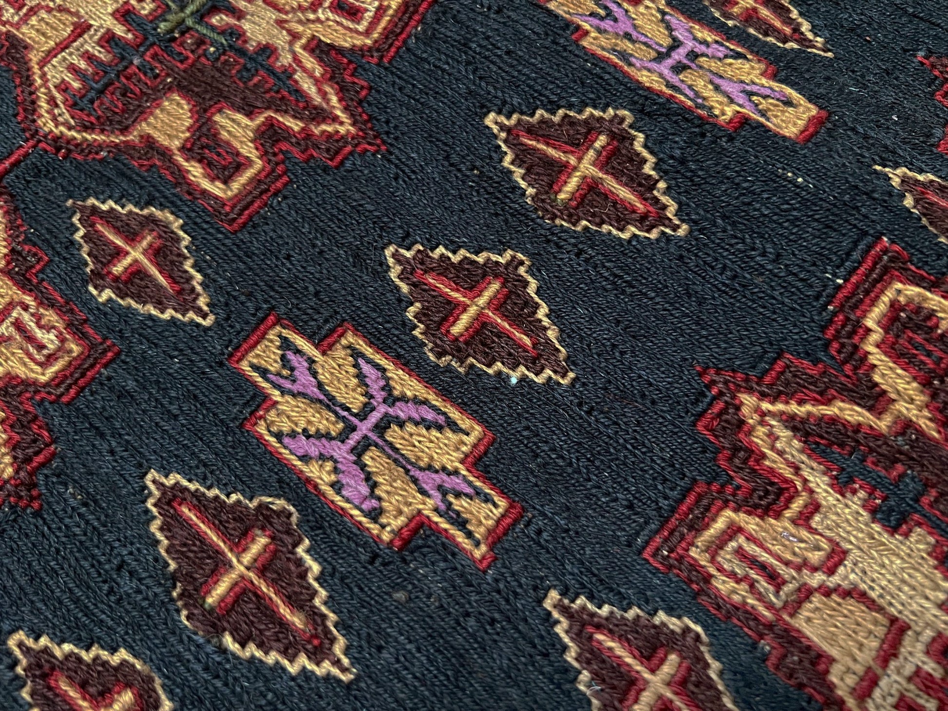 Vintage Caucasian Soumak flatweave rug with charcoal gray field, madder red rose motifs, and intricate tribal borders — handmade wool wall hanging from the 1950s, available at Indigo Rugs, the best rug shop in San Francisco Bay Area, Burlingame CA.