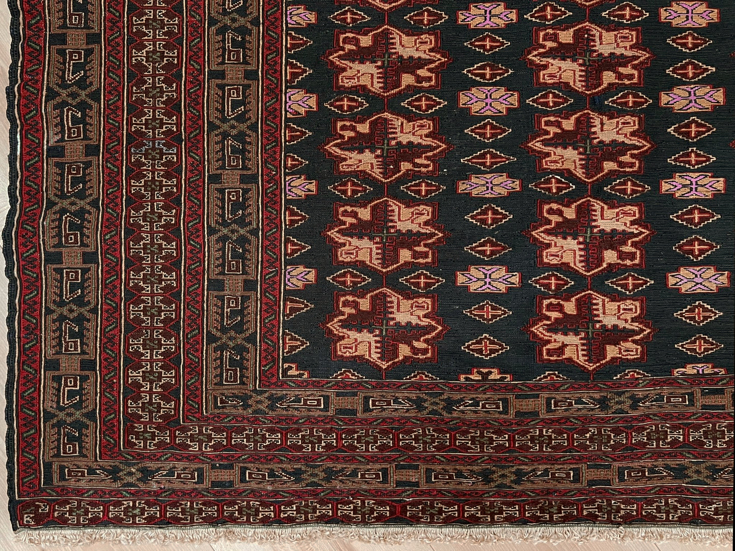 Vintage Caucasian Soumak flatweave rug with charcoal gray field, madder red rose motifs, and intricate tribal borders — handmade wool wall hanging from the 1950s, available at Indigo Rugs, the best rug shop in San Francisco Bay Area, Burlingame CA.