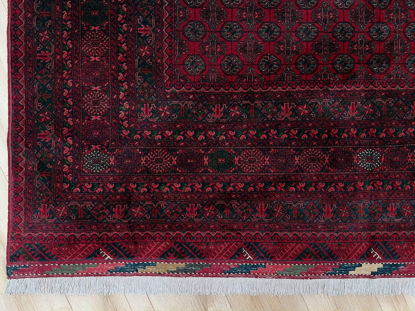 Traditional Turkmen Khoja Roshnai rug with crimson field, repeating gul motifs, navy borders, handmade merino wool area rug 7x10 with velvety pile from Indigo Rugs Burlingame Bay Area.