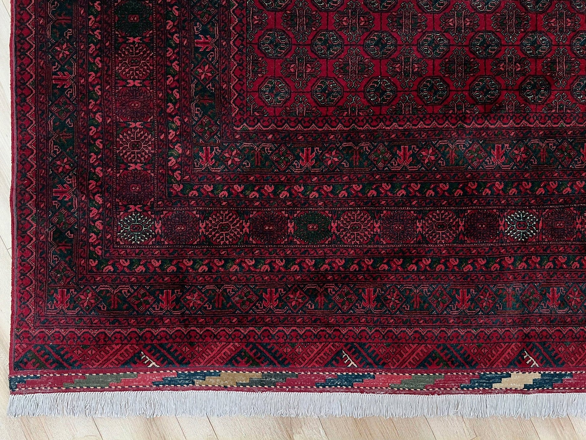 Traditional Turkmen Khoja Roshnai rug with crimson field, repeating gul motifs, navy borders, handmade merino wool area rug 7x10 with velvety pile from Indigo Rugs Burlingame Bay Area.