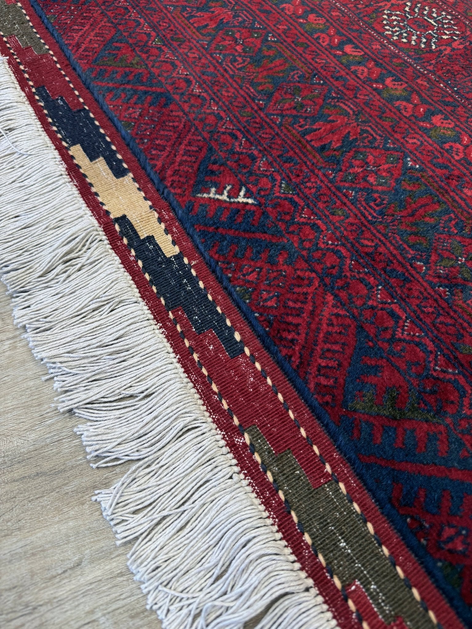 Traditional Turkmen Khoja Roshnai rug with crimson field, repeating gul motifs, navy borders, handmade merino wool area rug 7x10 with velvety pile from Indigo Rugs Burlingame Bay Area.