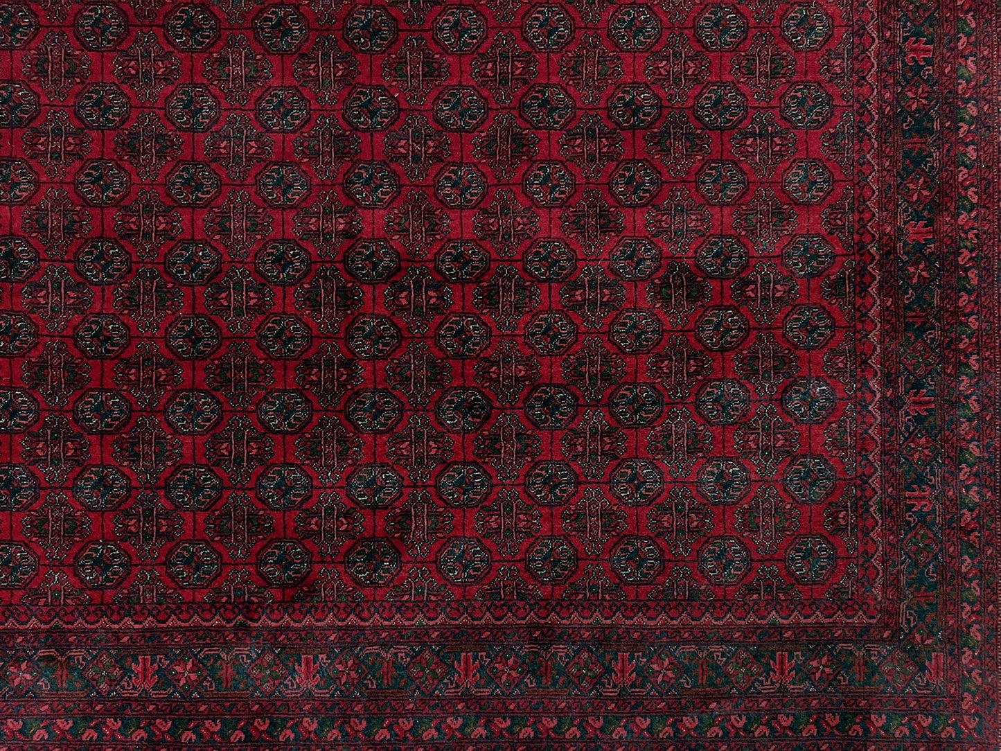 Traditional Turkmen Khoja Roshnai rug with crimson field, repeating gul motifs, navy borders, handmade merino wool area rug 7x10 with velvety pile from Indigo Rugs Burlingame Bay Area.