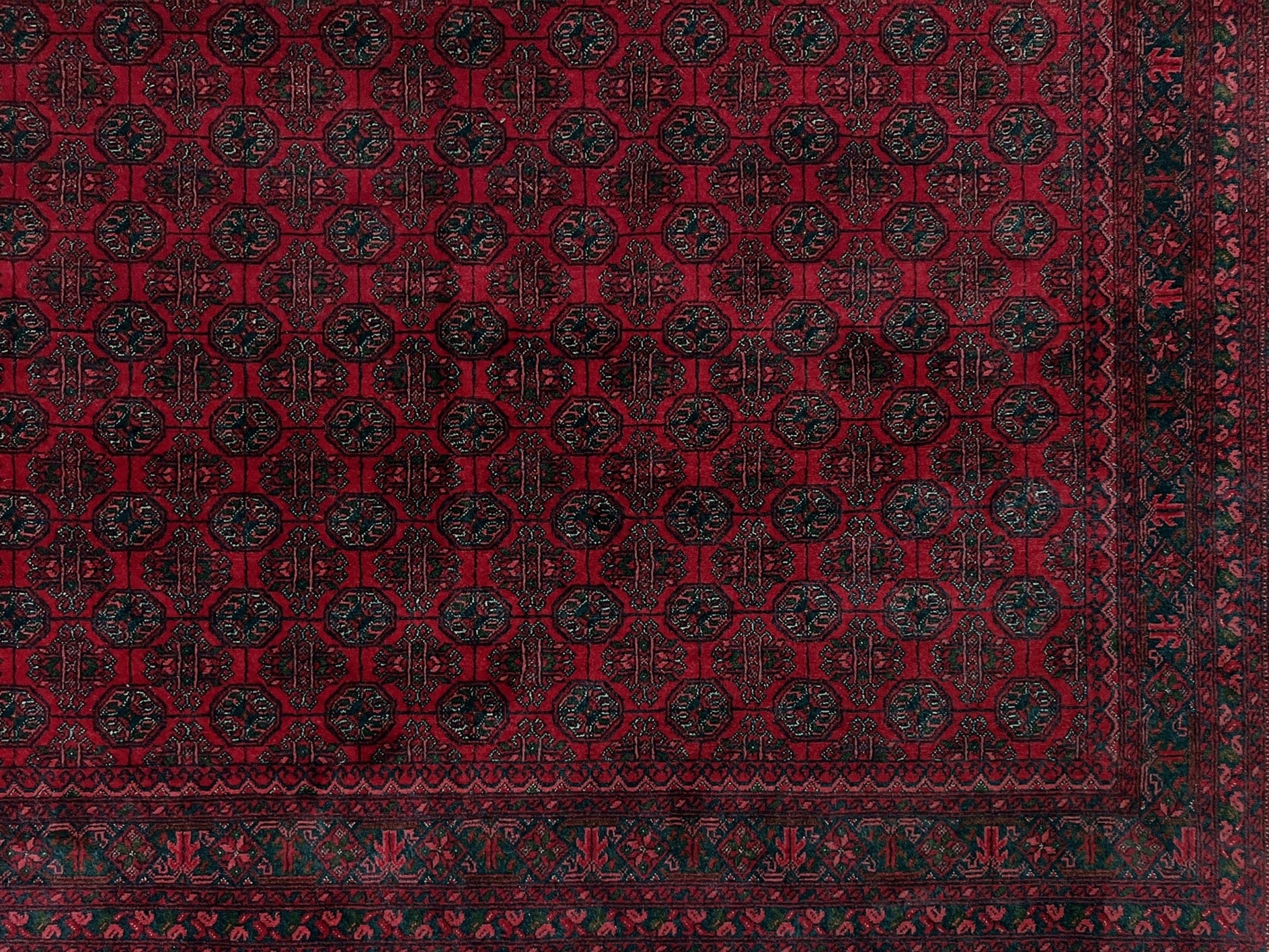 Traditional Turkmen Khoja Roshnai rug with crimson field, repeating gul motifs, navy borders, handmade merino wool area rug 7x10 with velvety pile from Indigo Rugs Burlingame Bay Area.