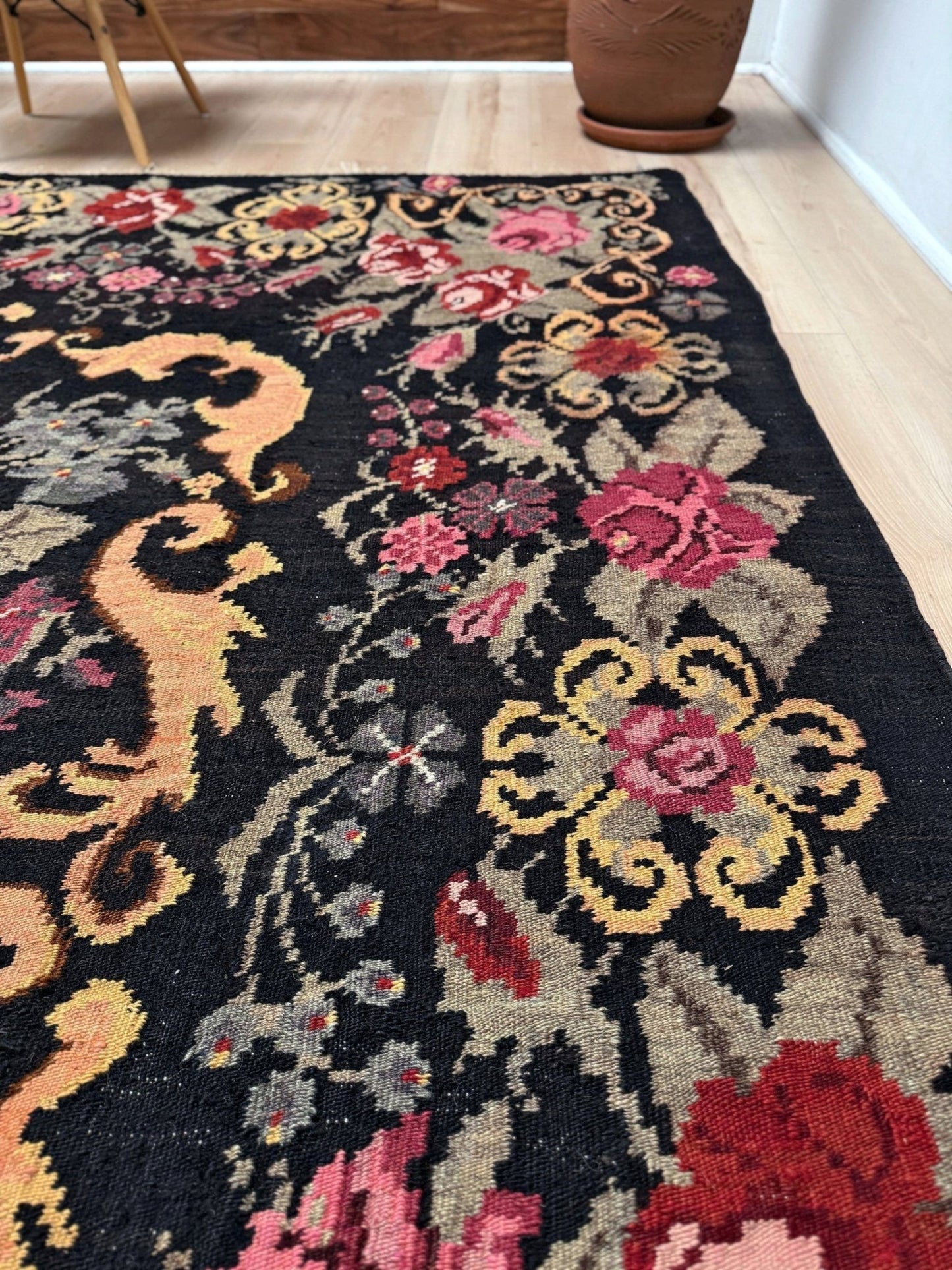 Decorative moldovan rose kilim rug with floral patterns on a wooden floor