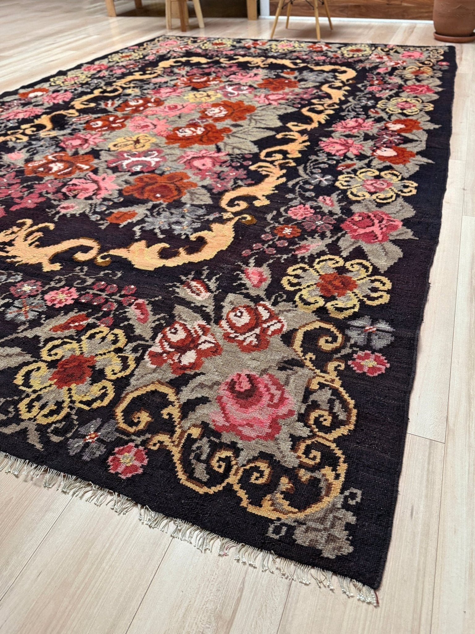 Decorative moldovan rose kilim rug with floral patterns on a wooden floor