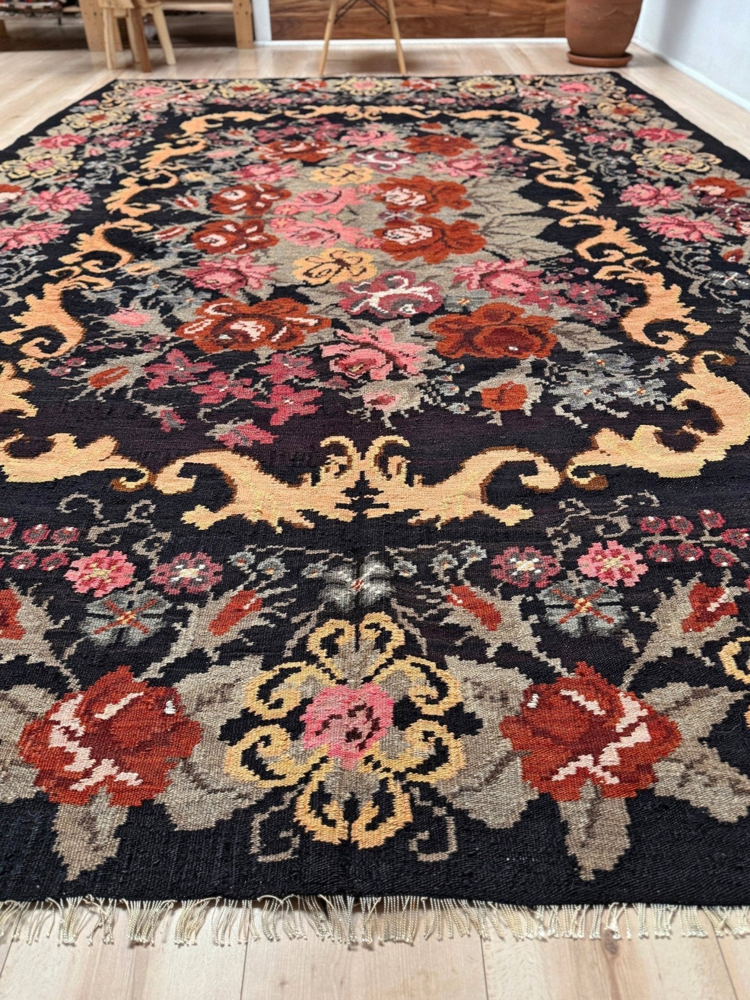 Decorative moldovan rose kilim rug with floral patterns on a wooden floor