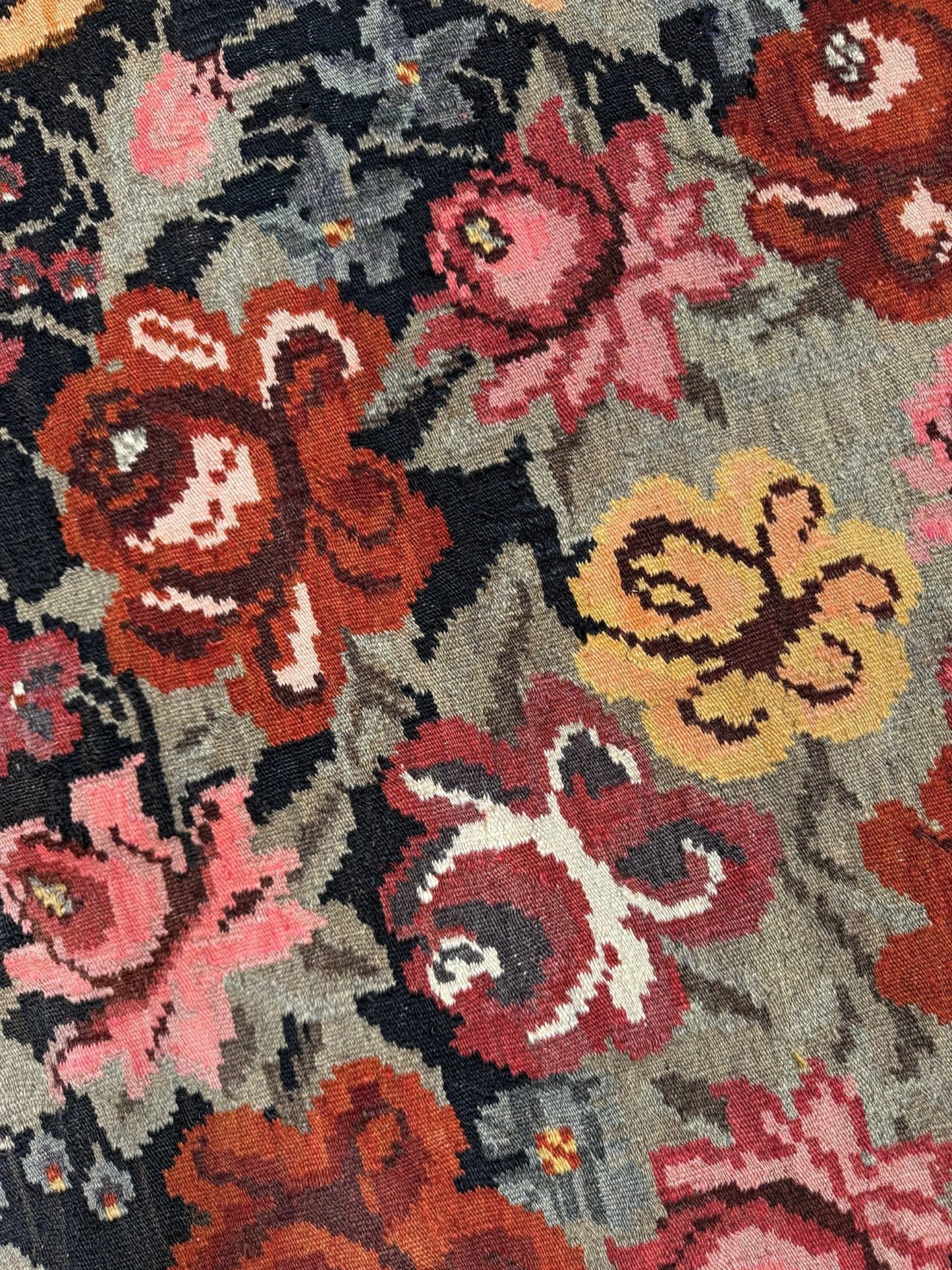 Close-up of a floral patterned moldovan rose kilim rug with multicolor flowers.