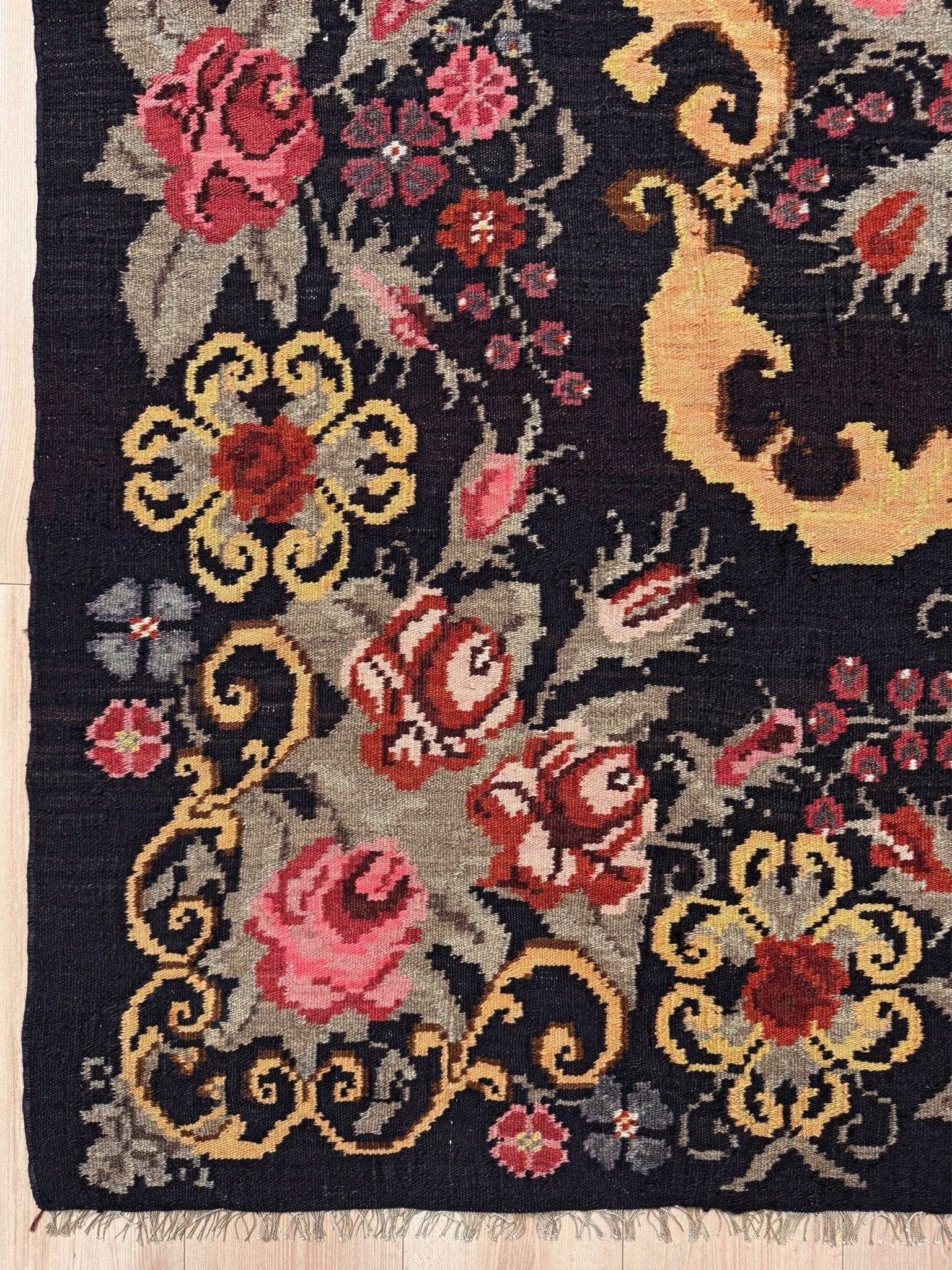 Decorative moldovan rose kilim  rug with floral and paisley patterns on a dark background