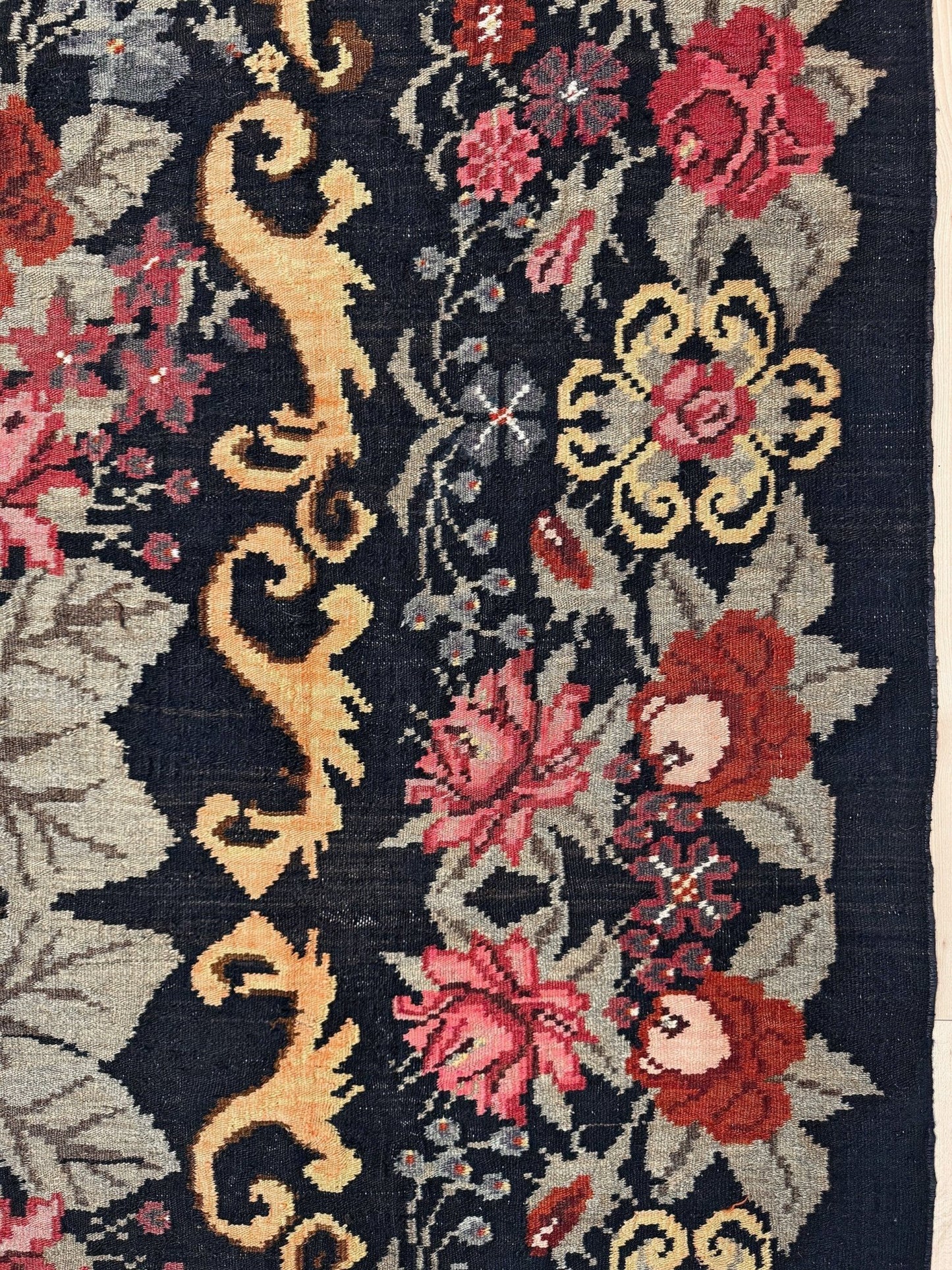 Decorative moldovan rose kilim rug with floral and dragon designs on a dark background