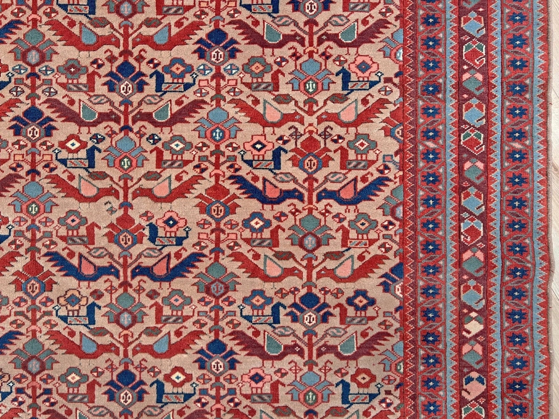 Brand new 6x9 handmade Turkish Tree of Life rug in muted peach with birds, floral motifs, coral red and blue accents, traditional wool area rug from Indigo Rugs Burlingame Bay Area.