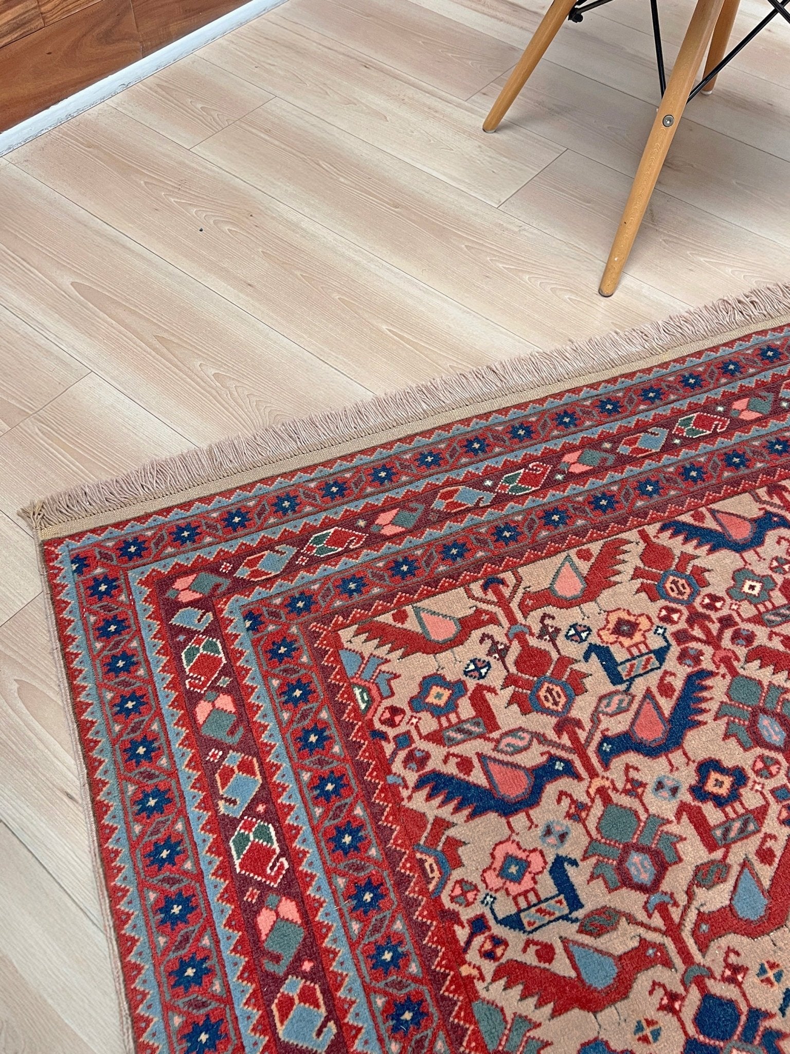 Brand new 6x9 handmade Turkish Tree of Life rug in muted peach with birds, floral motifs, coral red and blue accents, traditional wool area rug from Indigo Rugs Burlingame Bay Area.