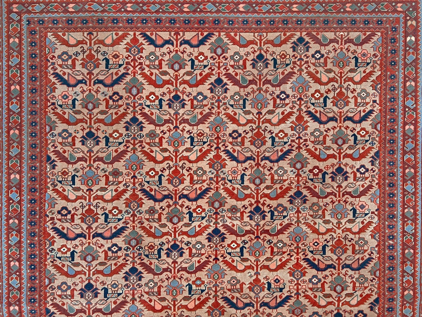 Brand new 6x9 handmade Turkish Tree of Life rug in muted peach with birds, floral motifs, coral red and blue accents, traditional wool area rug from Indigo Rugs Burlingame Bay Area.