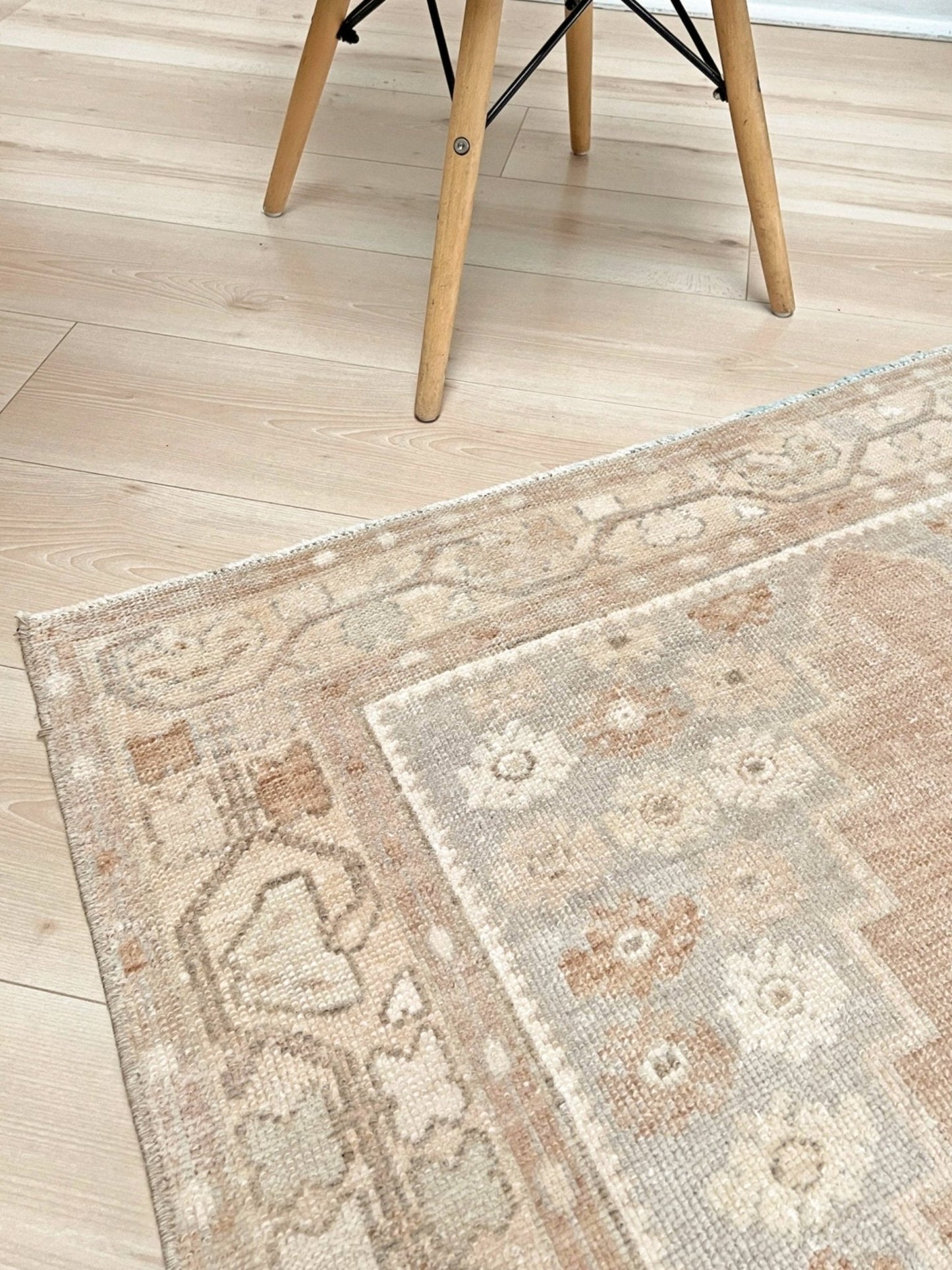 Patterned rug on a wooden floor with a chair visible