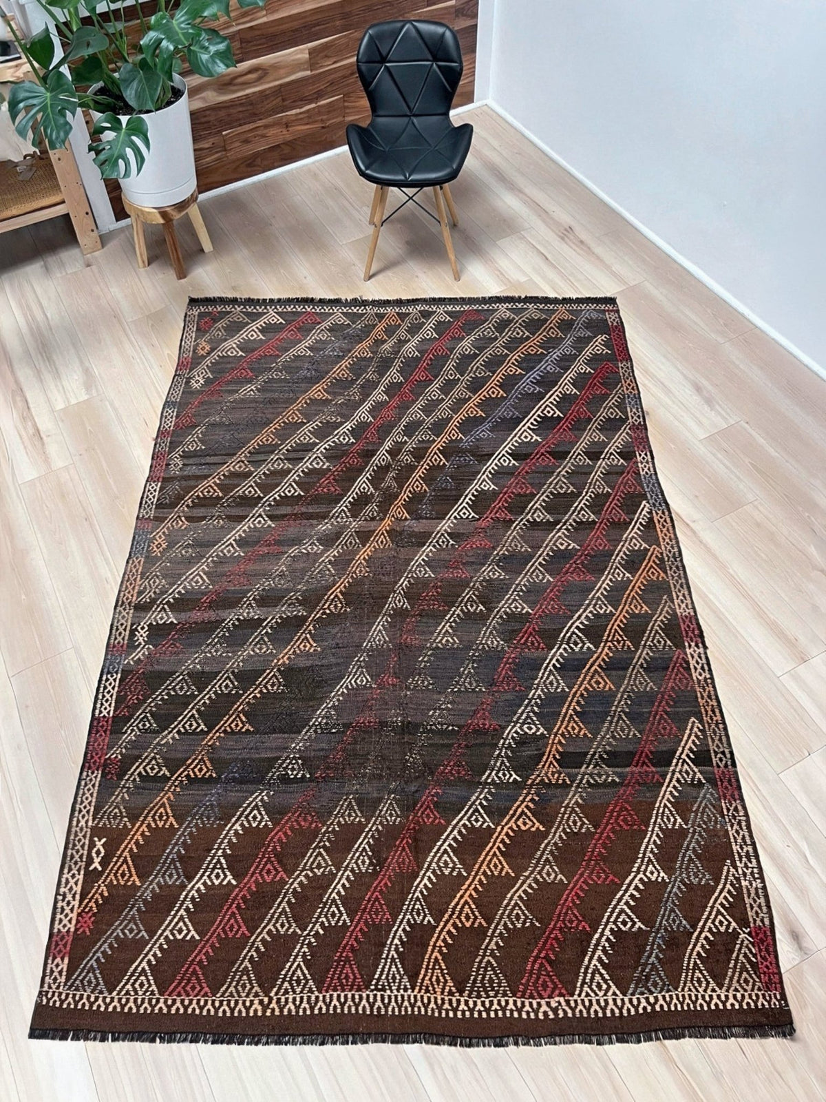 Woven textile with geometric pattern on a plain background. Vintage distressed Konya cicim kilim rug 6x8 with espresso-brown field, tribal embroidered motifs, and earthy tones — handmade Turkish flatweave carpet