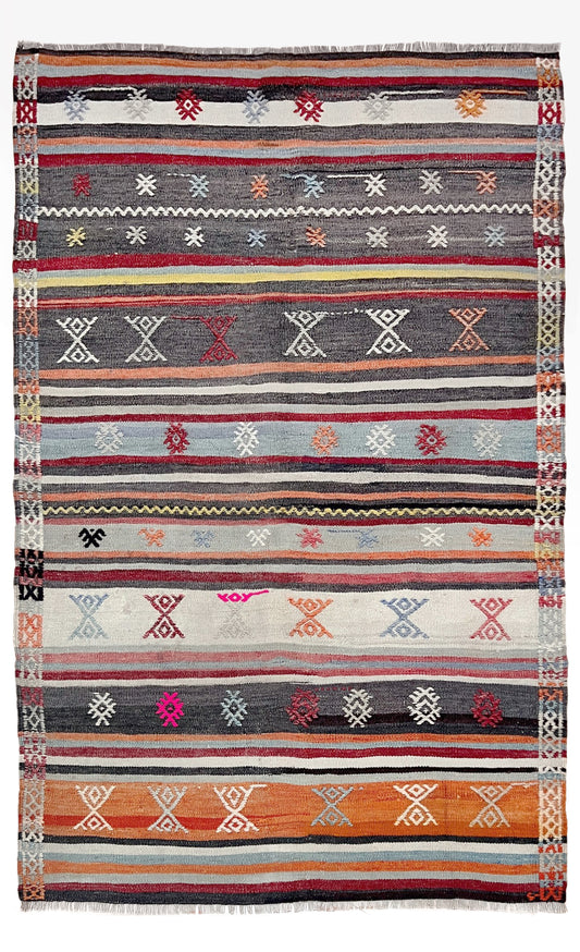 Multicolored striped rug with geometric patterns on a white background. Vintage Turkish striped kilim rug, 4x6, with tribal motifs in charcoal, ivory, sky blue, coral, and red bands.