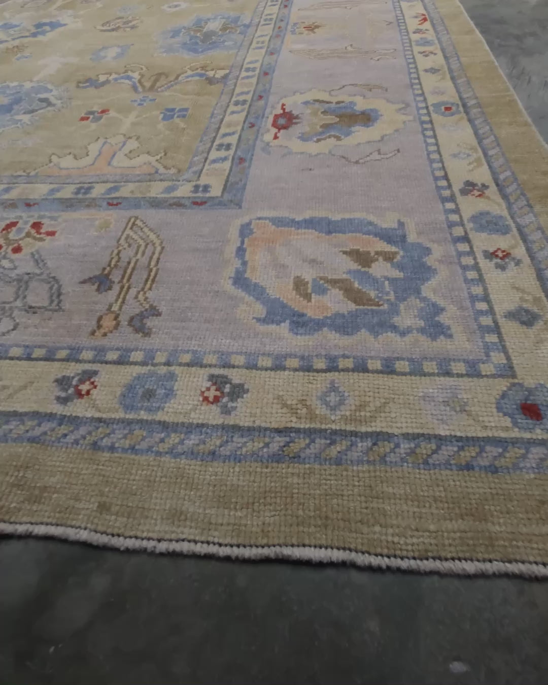 Light olive Turkish Oushak rug with warm ivory border, powder blue floral motifs, soft gray, taupe, and rust accents, hand-knotted wool 10x14 area rug from Indigo Rugs Burlingame Bay Area.