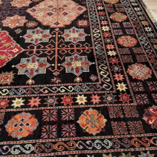 Handmade Turkmen-style 9x12 wool rug with Caucasian-inspired design, rich black, crimson, ivory, and sage hues. Luxury area rug with intricate medallions and floral motifs, perfect for bedroom, living room, or dining room. High-quality craftsmanship from the best rug shop in Burlingame CA, SF Bay Area. Free shipping, timeless character, and elegance for any space.