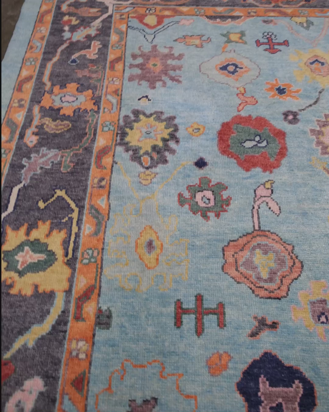 Pale turquoise Turkish Oushak rug with charcoal border, coral orange framing, and colorful abstract floral motifs, hand-knotted wool 8x10 area rug from Indigo Rugs Burlingame Bay Area.