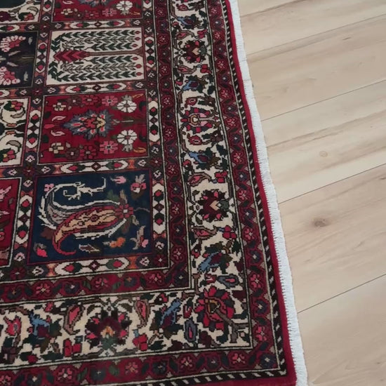 Vintage Persian Bakhtiari rug wit red field, navy garden panels, ivory details, and intricate floral motifs, handmade wool area rug 5x8 from Indigo Rugs Burlingame SF Bay Area