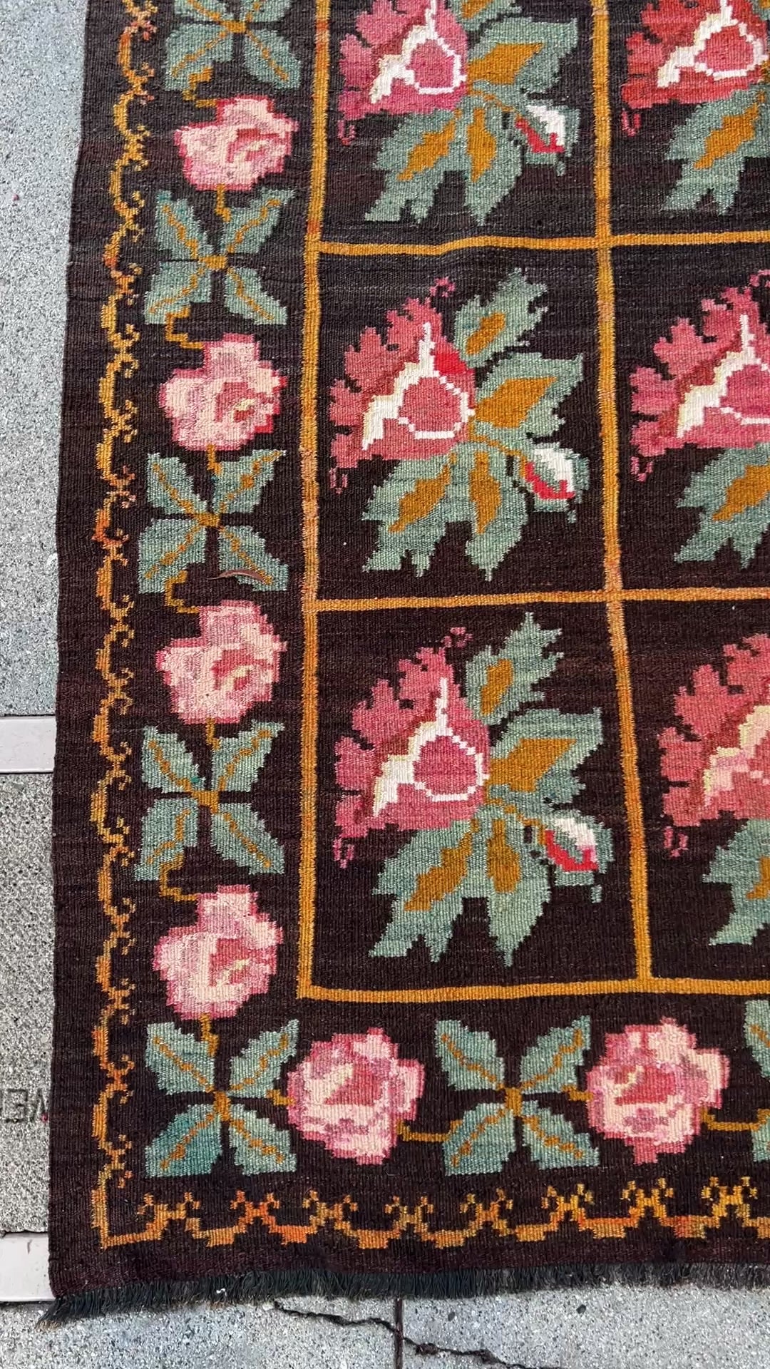 Vintage Moldovan Rose Kilim Rug from the 1950s, featuring a bold black ground with vibrant pink rose motifs and orange lines woven throughout. Handwoven with care, this flatweave rug adds unique character and style to living rooms, bedrooms, nurseries, kitchens, or dining areas. Free shipping included.