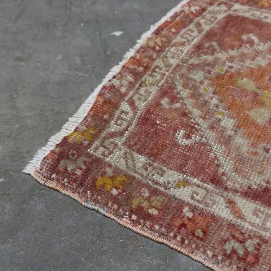 Antique Turkish handmade mini rug with dusty terracotta field, faded peach. Hand-knotted wool, 19x36 inches. Circa 1930s–1950s. Perfect for: Entryways, apartment foyers, beside the bed, kitchen sink areas, bathroom vanity spots. One-of-a-kind piece from Indigo Rugs in Burlingame, the best rug shop in the San Francisco Bay Area. Free shipping included. 