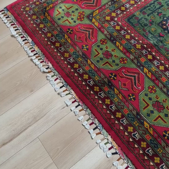 Forest green Bilcik Turkmen rug with cherry red border, geometric tribal motifs, olive green, navy, mustard, burgundy and rust accents, handmade wool 10x14 afrom Indigo Rugs Burlingame Bay Area.
