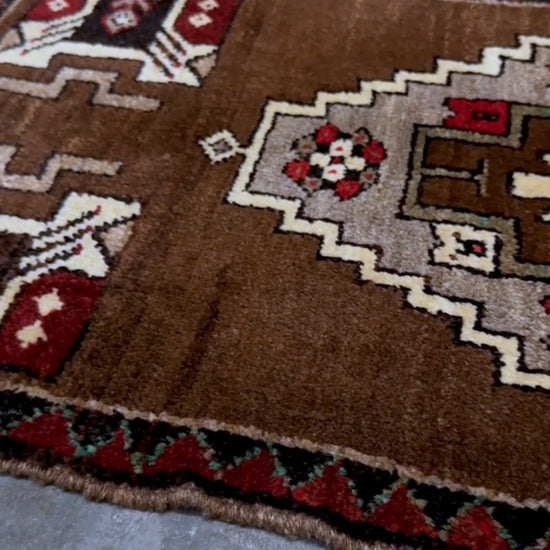 Vintage Turkish Yastik mini rug in walnut brown with taupe and camel medallion, espresso outlines, ivory highlights, and crimson red accents. Hand-knotted wool, 21x37 inches. One-of-a-kind rug from Indigo Rugs, the best rug shop in the San Francisco Bay Area (Burlingame, CA). Free shipping included.