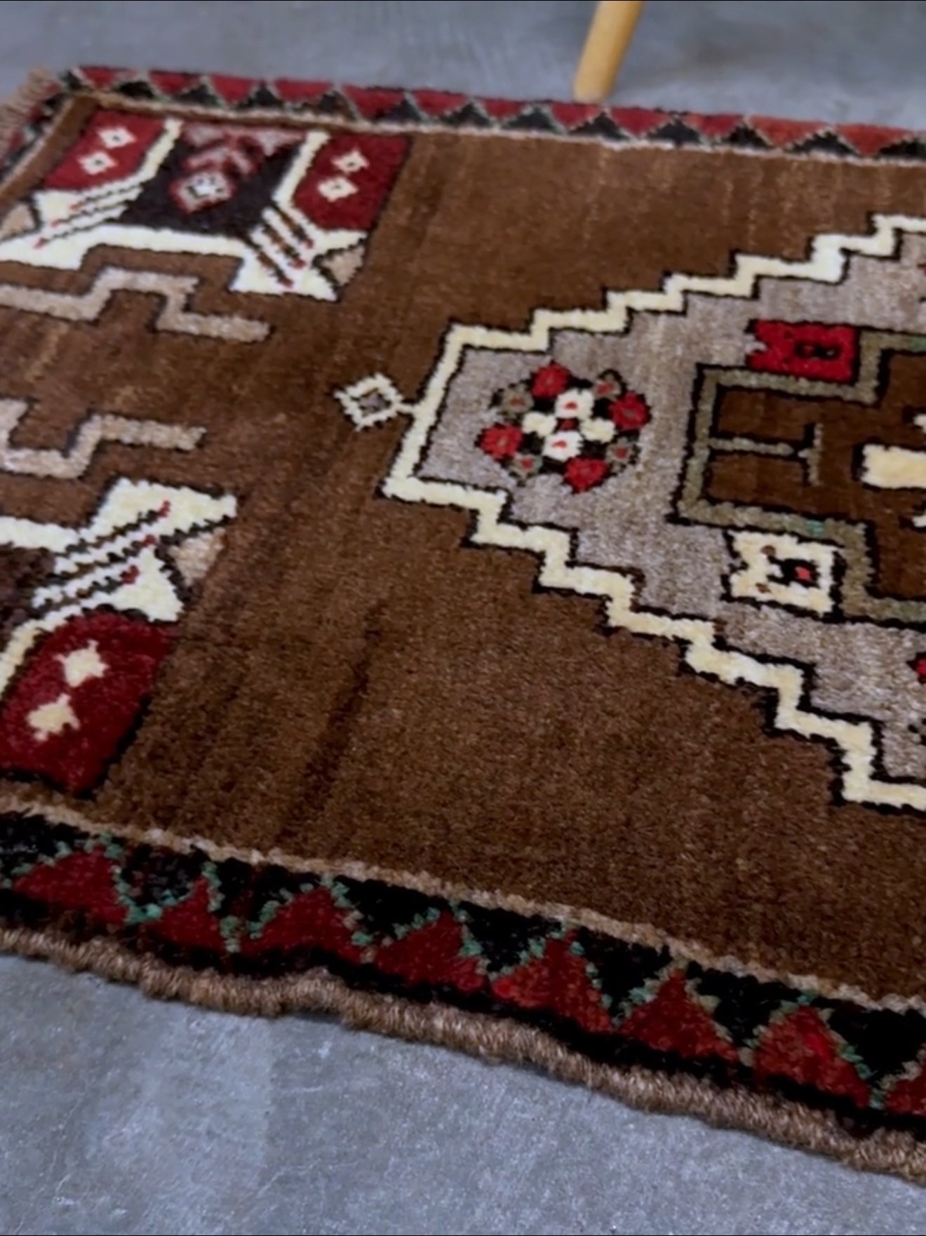 Vintage Turkish Yastik mini rug in walnut brown with taupe and camel medallion, espresso outlines, ivory highlights, and crimson red accents. Hand-knotted wool, 21x37 inches. One-of-a-kind rug from Indigo Rugs, the best rug shop in the San Francisco Bay Area (Burlingame, CA). Free shipping included.