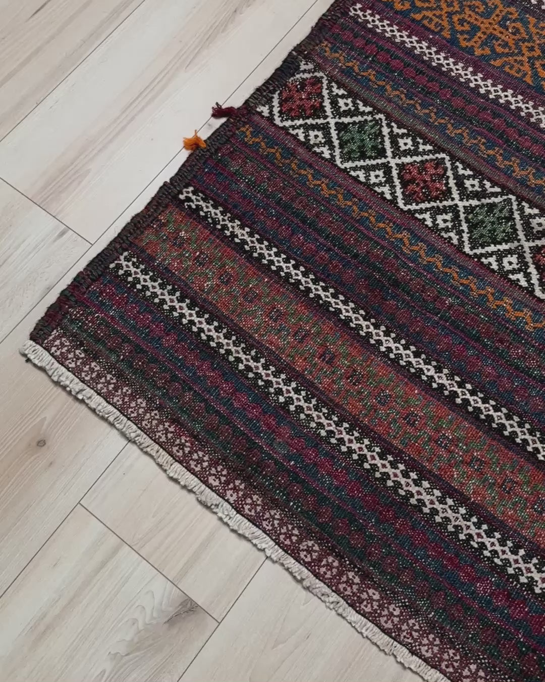 Vintage Persian tribal kilim rug with geometric horizontal bands, brick red, indigo blue, orange, decorative side tassels, handmade wool flatweave 5x6 from Indigo Rugs Burlingame Bay Area.