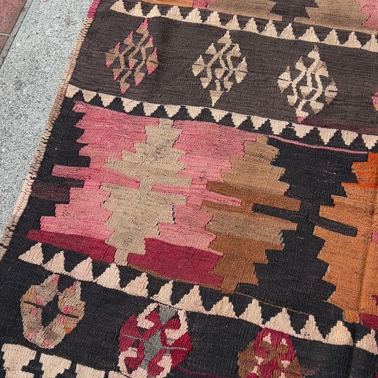 5x7 Kurdish Kilim rug from Eastern Turkey in slitweave technique, featuring bold geometric patterns in red, pink, and earthy tones. Offered by the best Kilim rug store in the San Francisco Bay Area, with free shipping to the US and Canada. A perfect gift idea for this season.